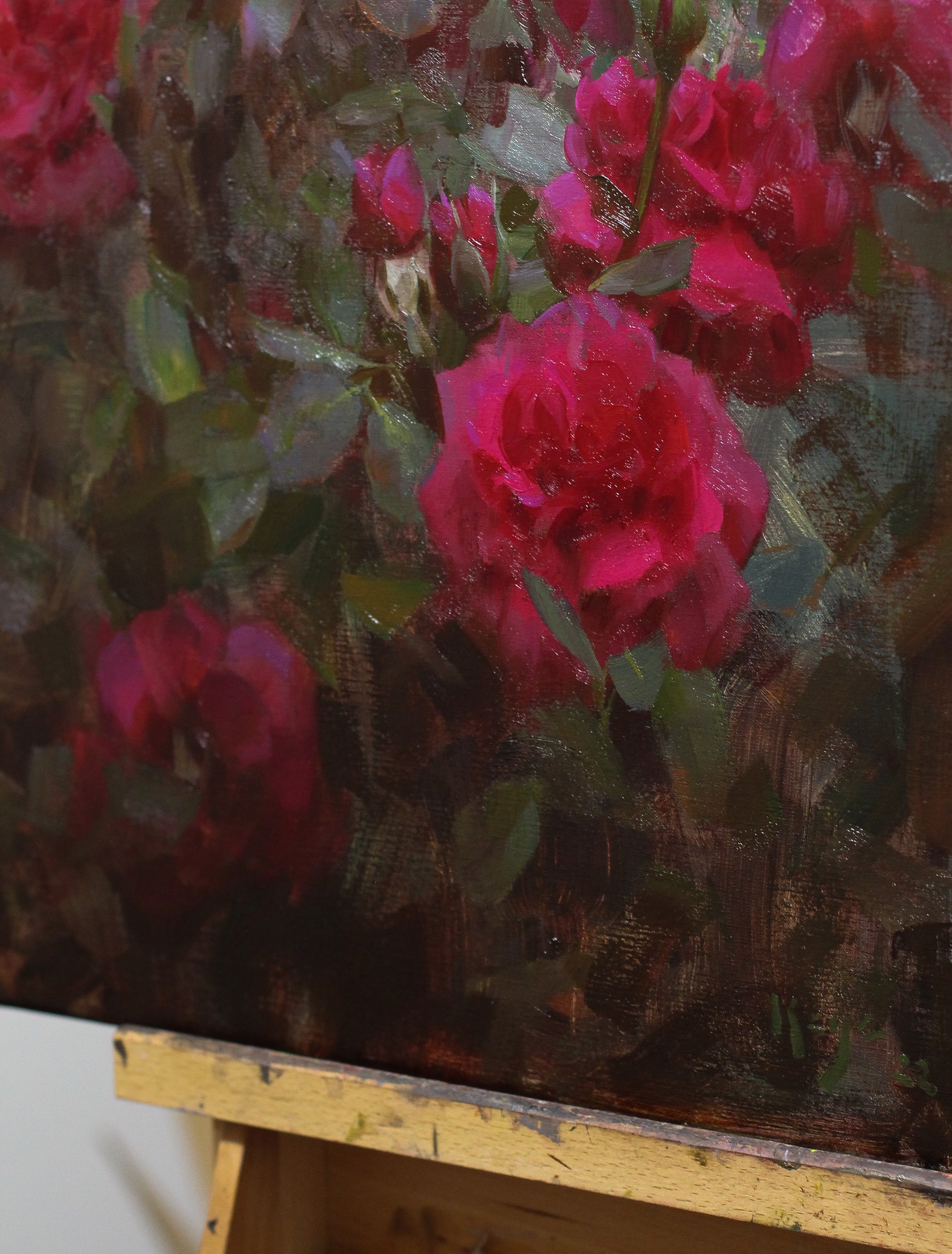 A painting of a bunch of red roses in a field.