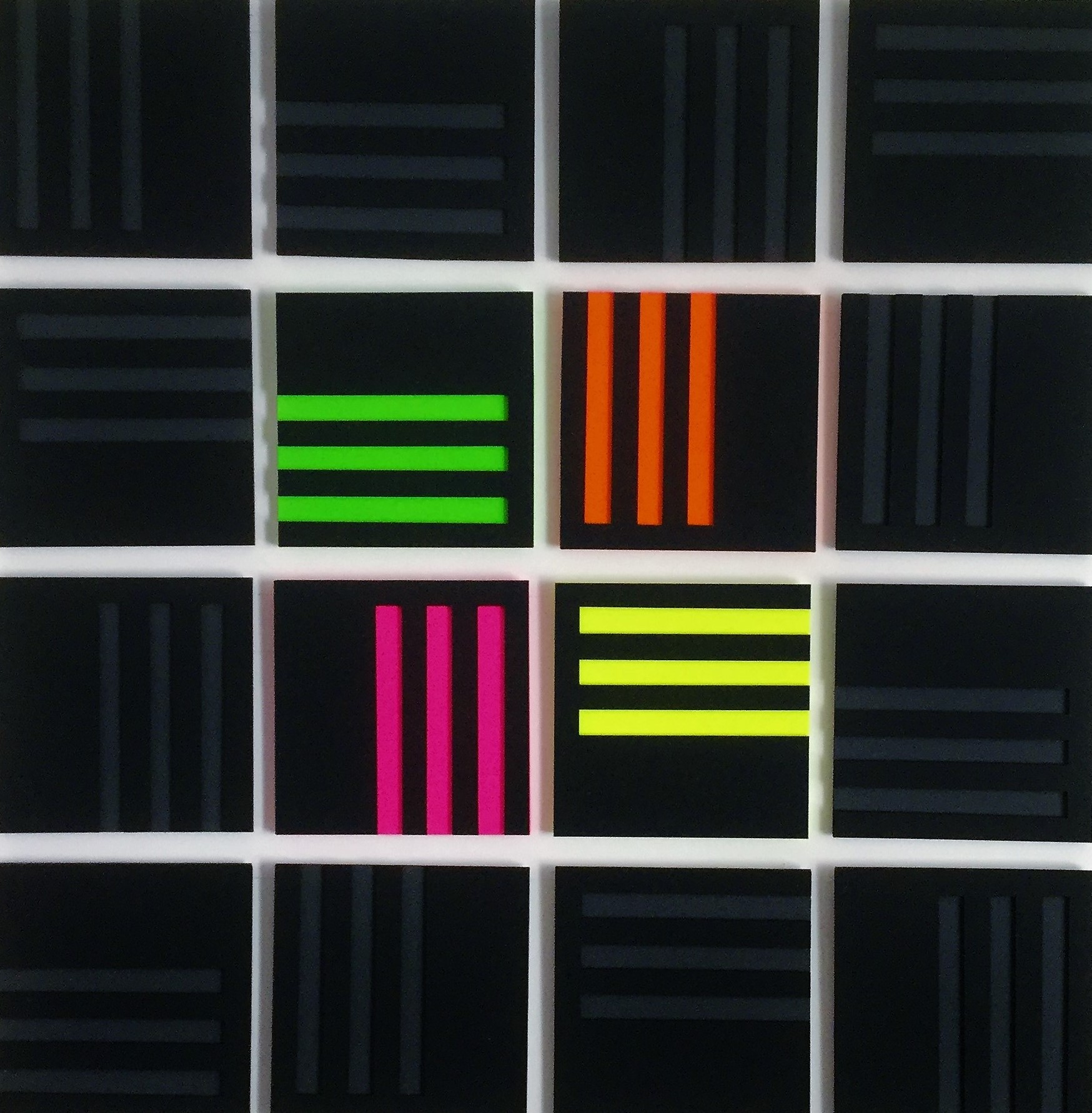 A set of six different colored squares on a white surface.