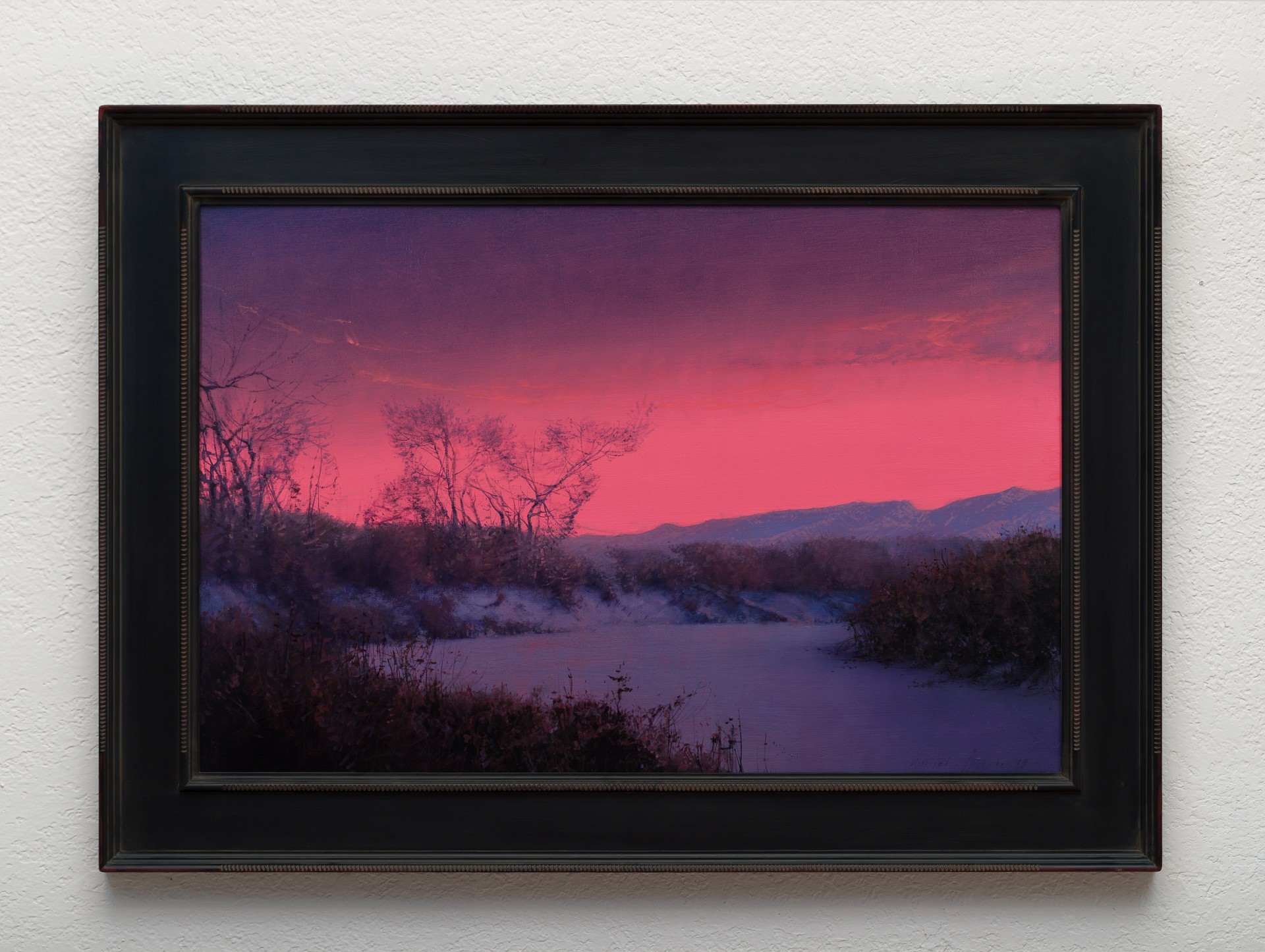 A winter landscape bathed in an intense pink and purple twilight glow.