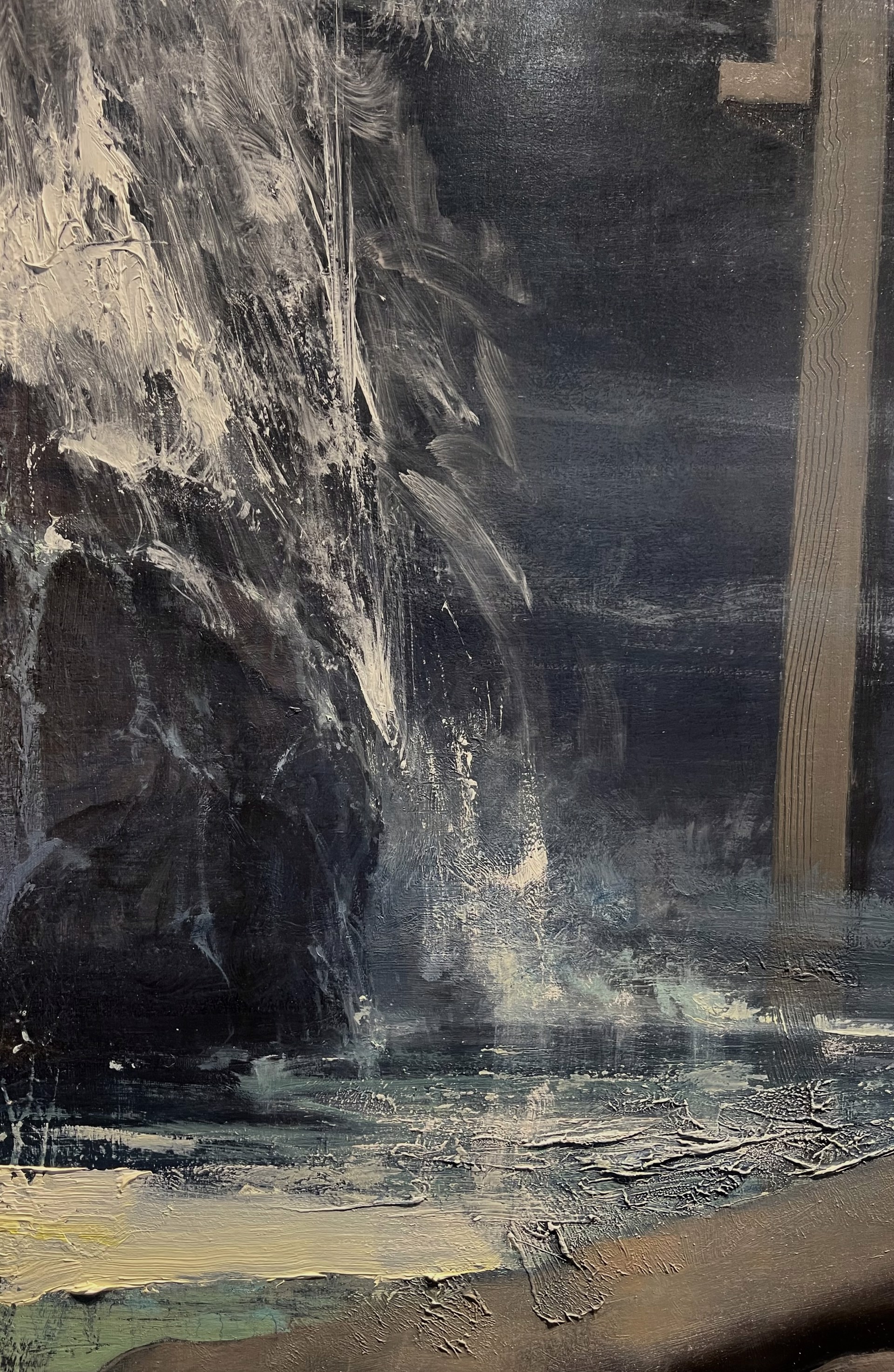 A nude figure lies on a dark surface in a dimly lit, atmospheric scene.