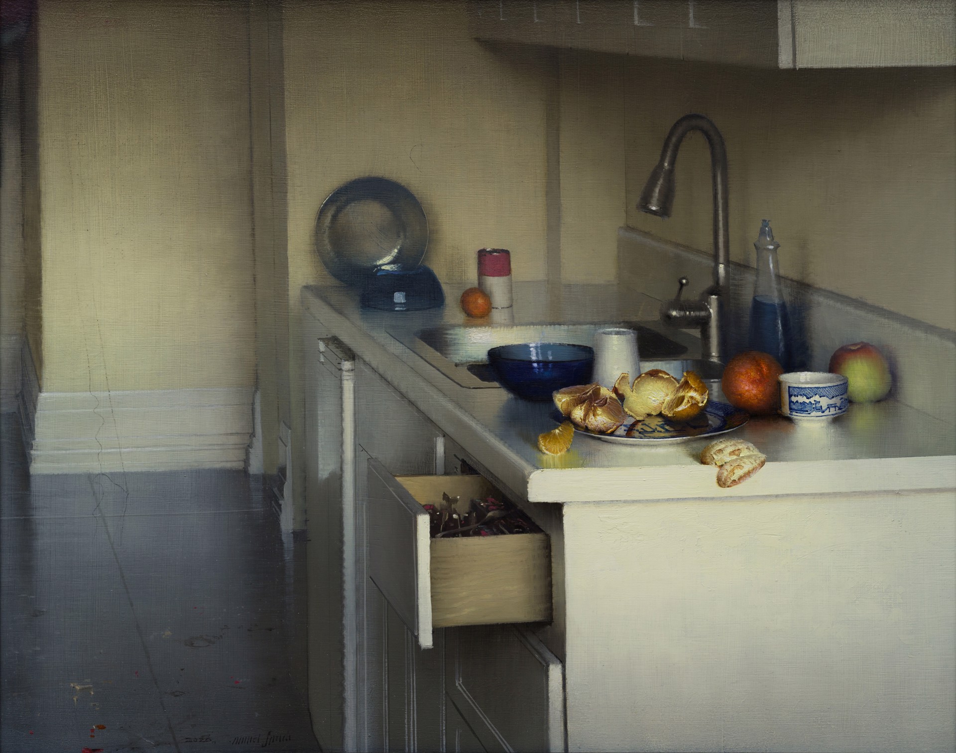 A quiet kitchen scene featuring a cluttered countertop with fruit, dishes, and an open drawer.