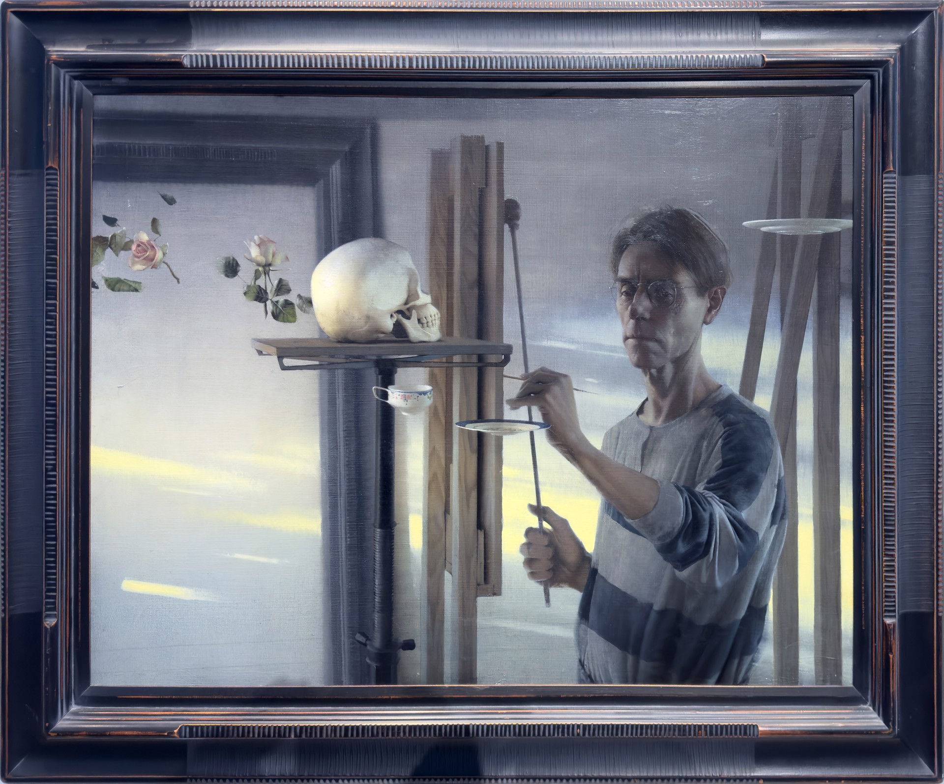 A painter in a studio works on a still life featuring a skull and delicate flowers.