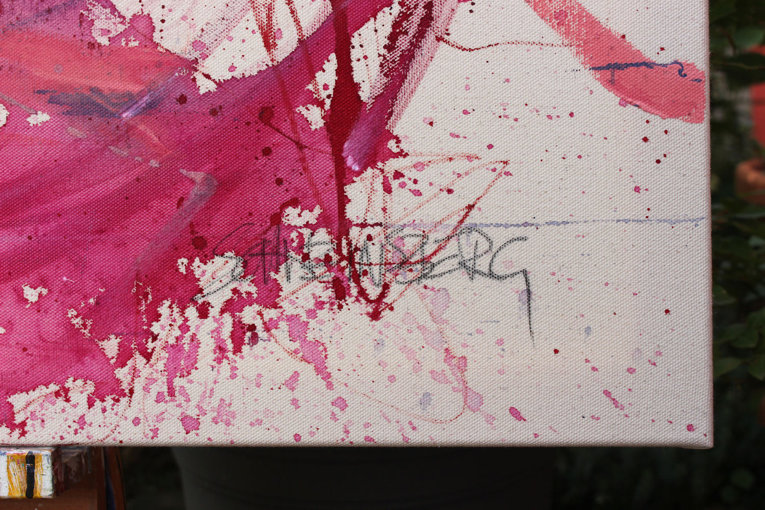 A painting with pink and blue paint splatters on a white background.