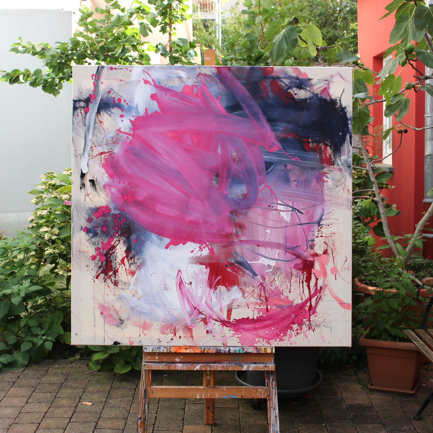 A painting with pink and blue paint splatters on a white background.