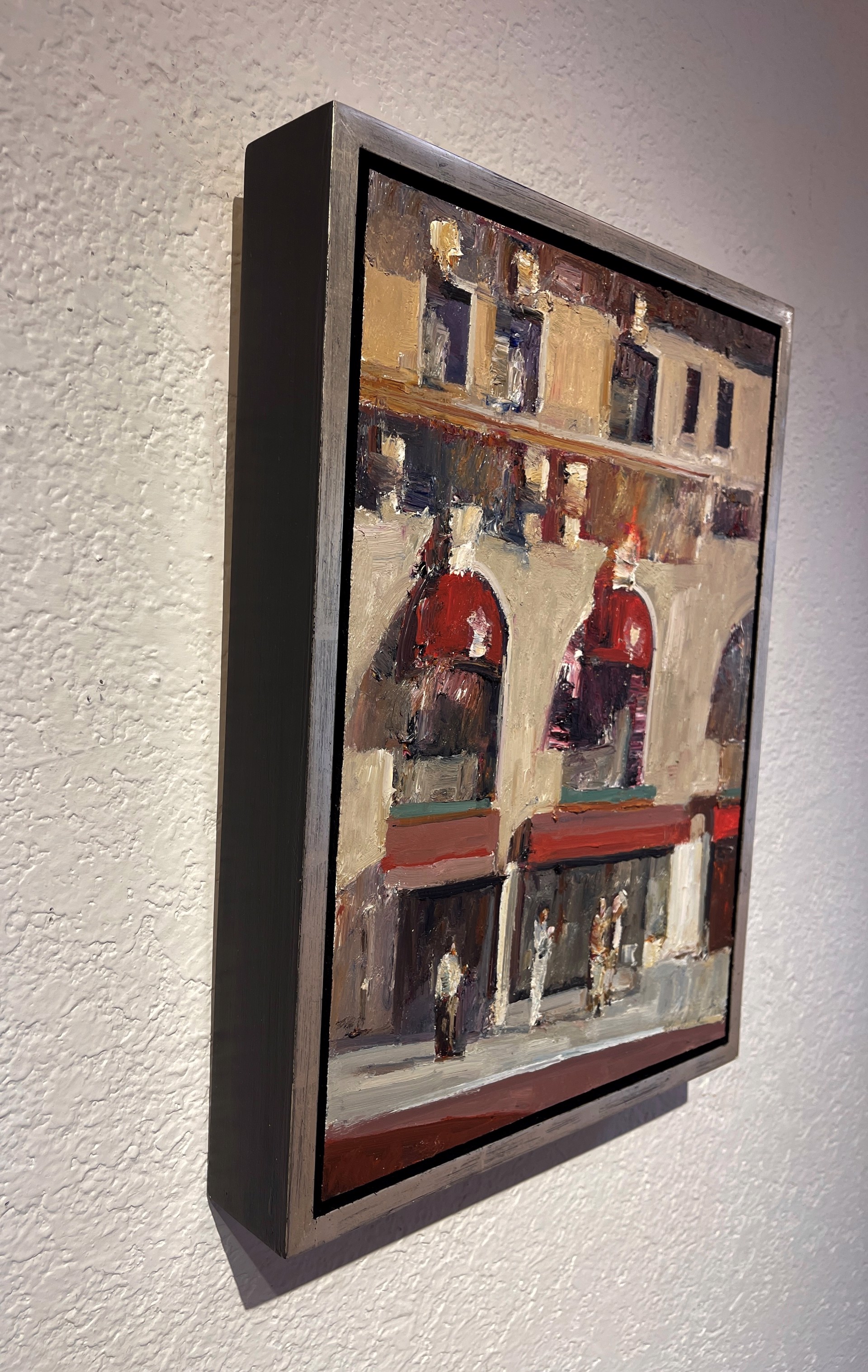 An expressive painting of a sunlit plaza with arched storefronts and figures gathered below.