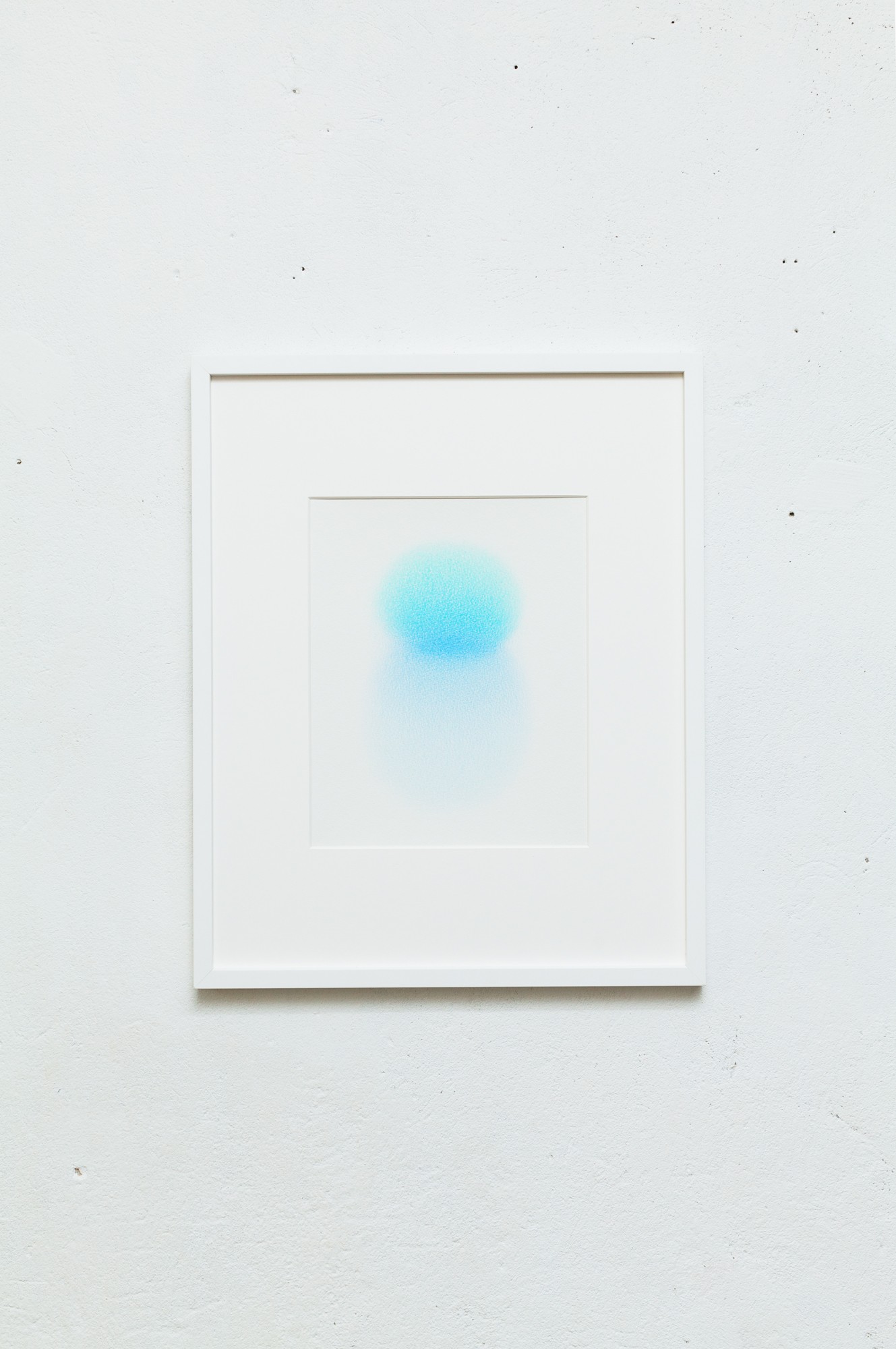 A white frame with a blue dot on a white wall.