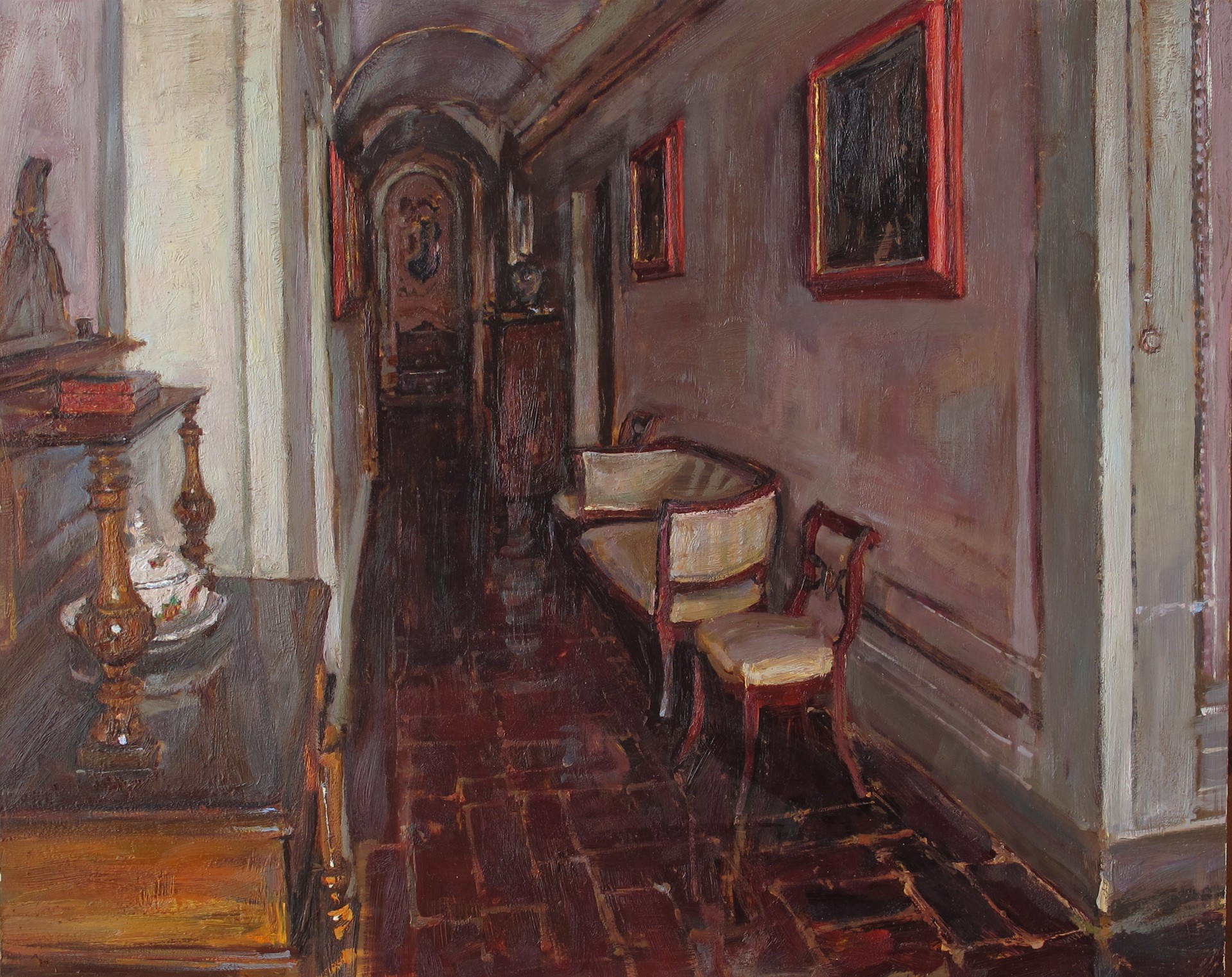 A dimly lit interior hallway featuring a bench, chair, and ornate furniture against muted walls.