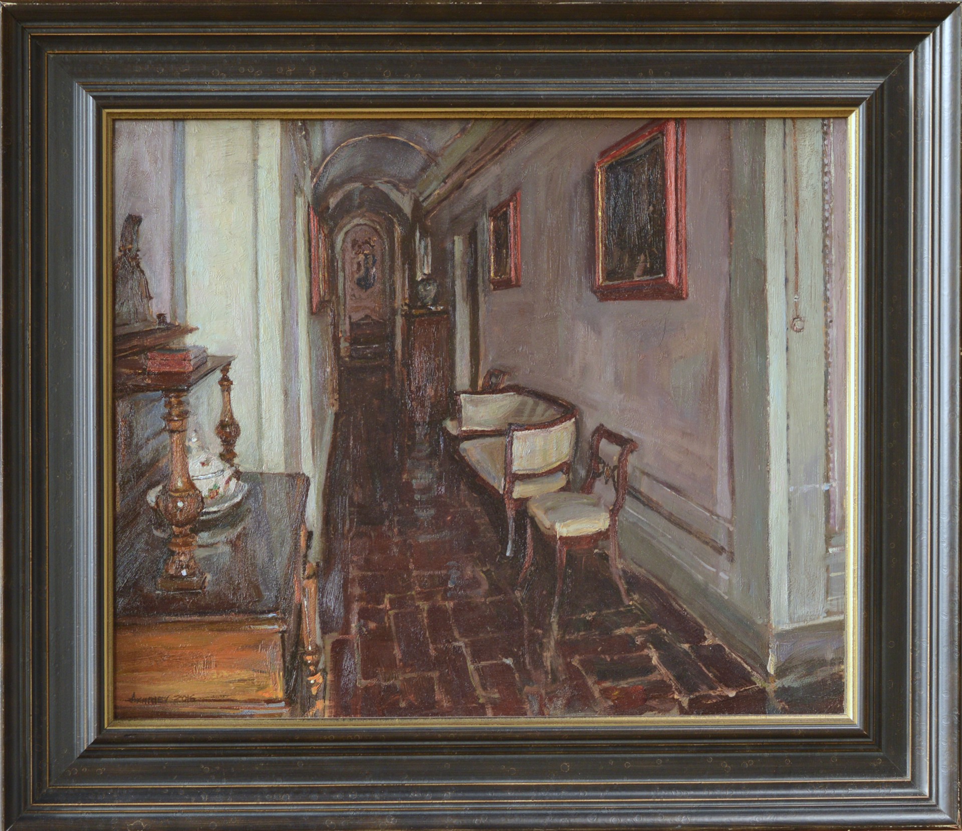 A dimly lit interior hallway featuring a bench, chair, and ornate furniture against muted walls.