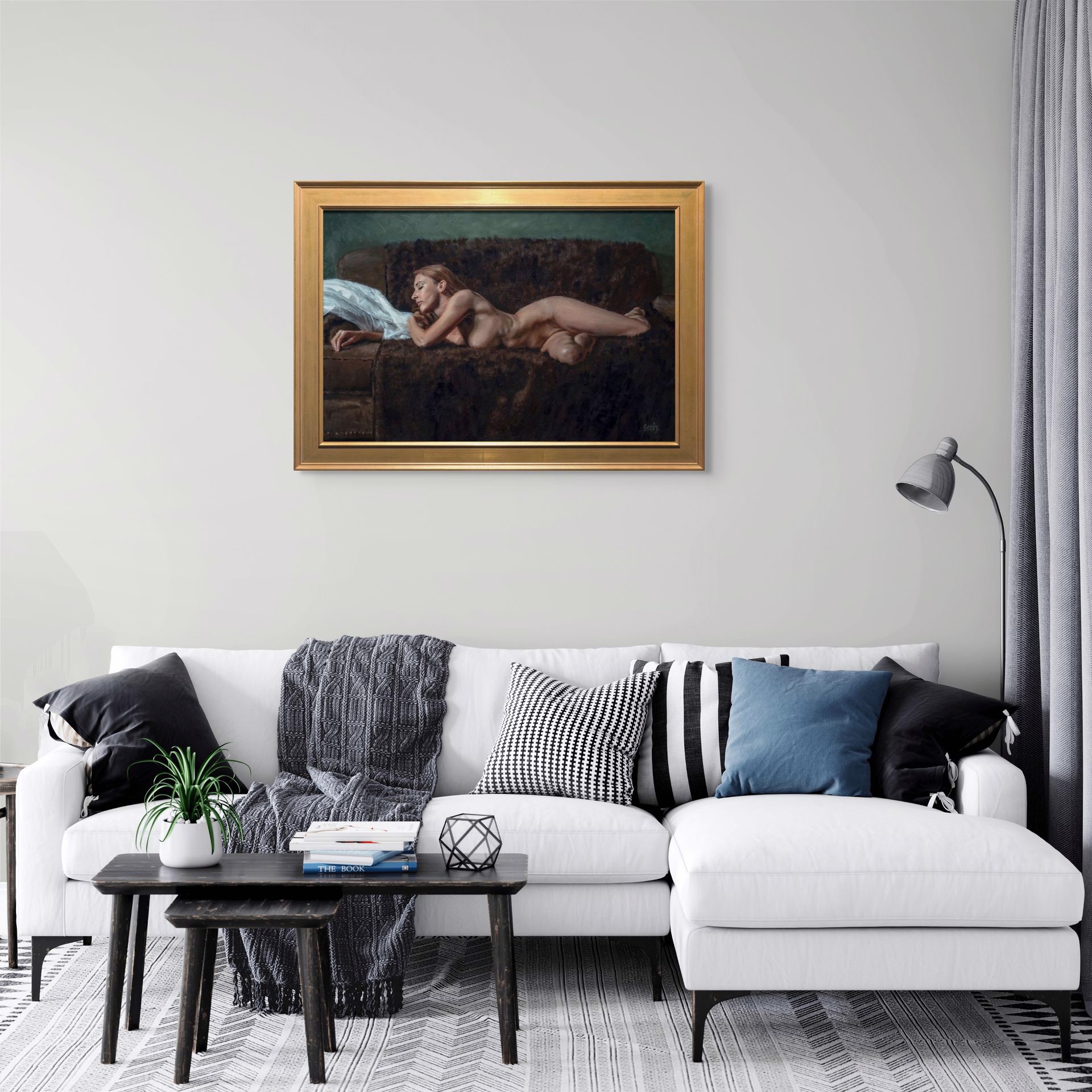 A nude figure rests on a dark sofa with a white sheet nearby.