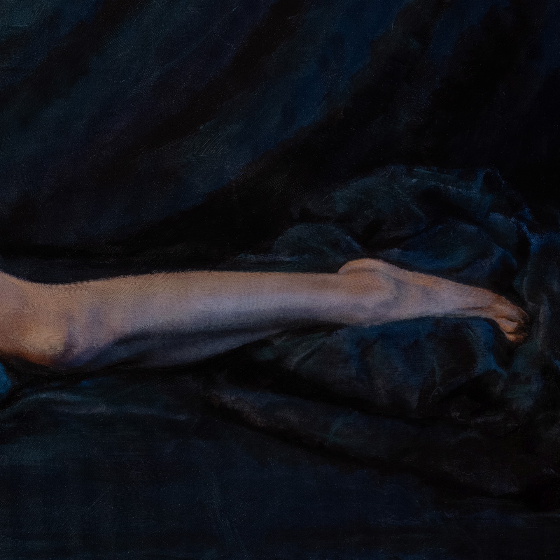 A figure with extensive colorful tattoos lies prone on a dark surface.