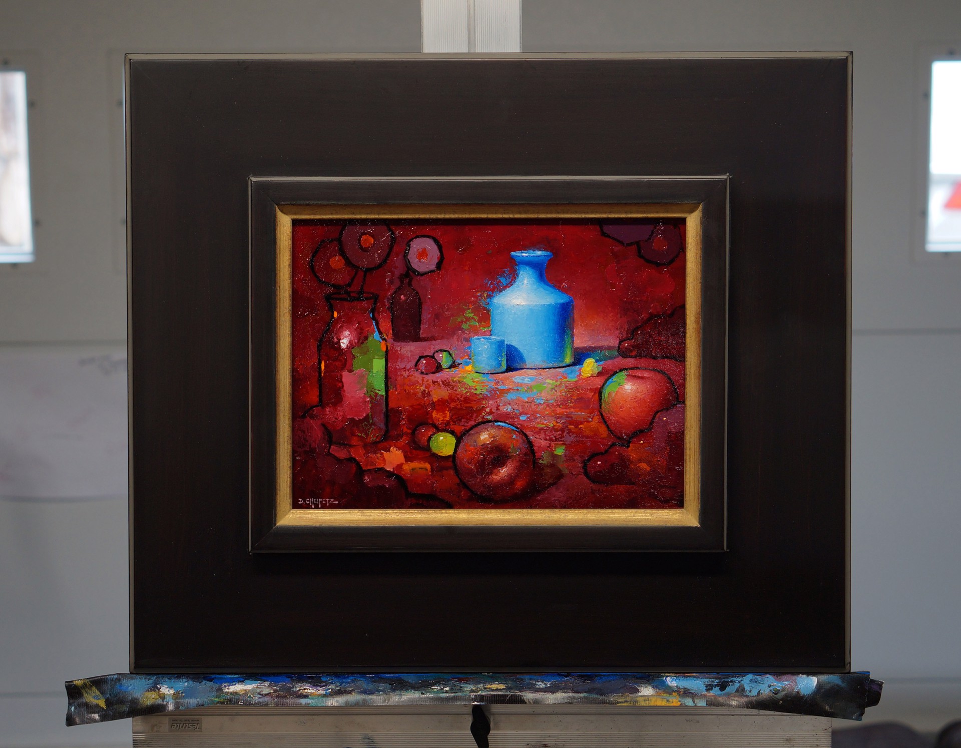 A vibrant still life featuring a blue vase, apples, and abstract shapes against a deep red background.