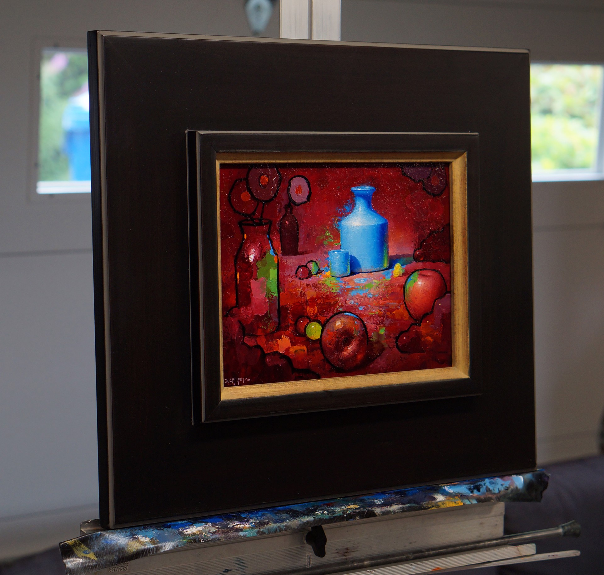A vibrant still life featuring a blue vase, apples, and abstract shapes against a deep red background.