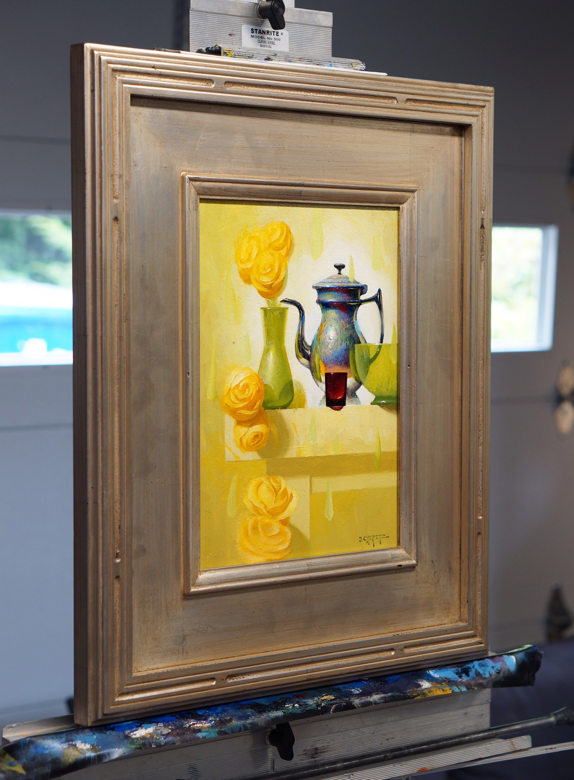 A still life painting featuring a metallic teapot, green vase with yellow roses, and abstract shapes on a light background.