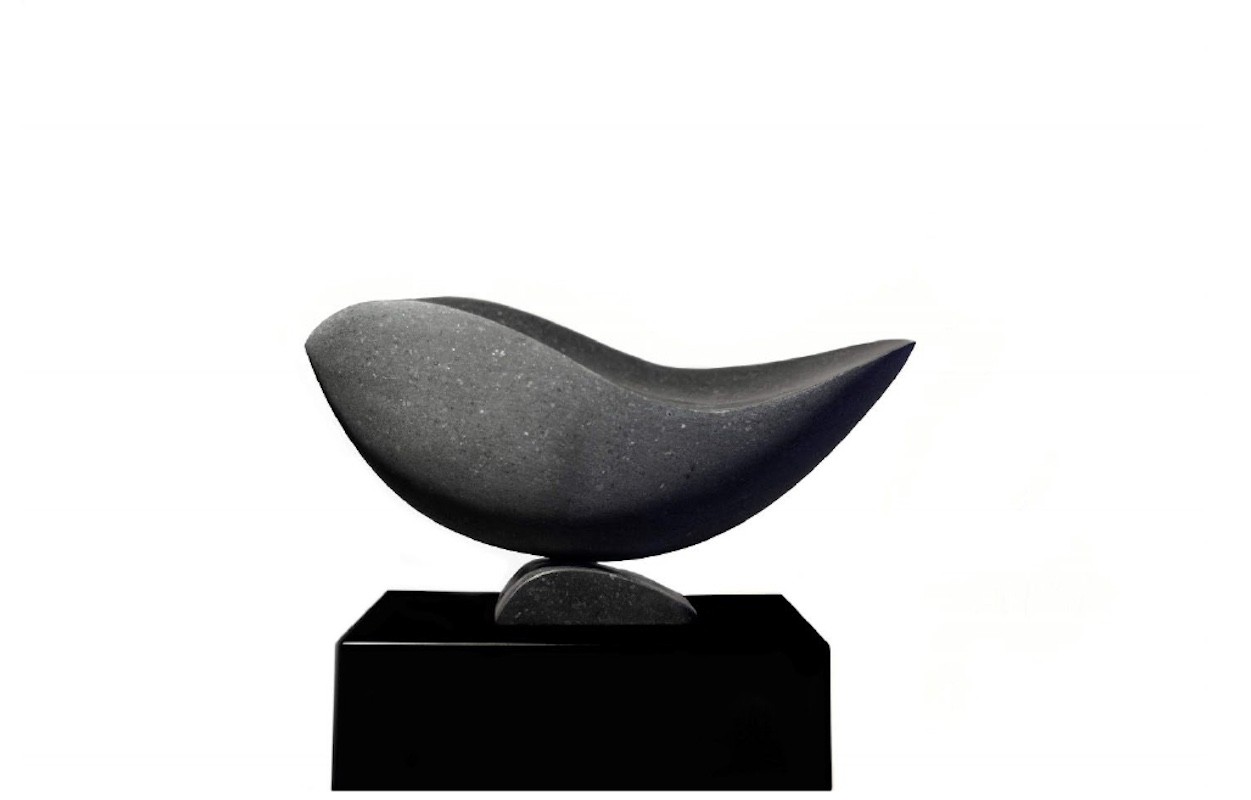 A black sculpture of a bird sitting on top of a black base.