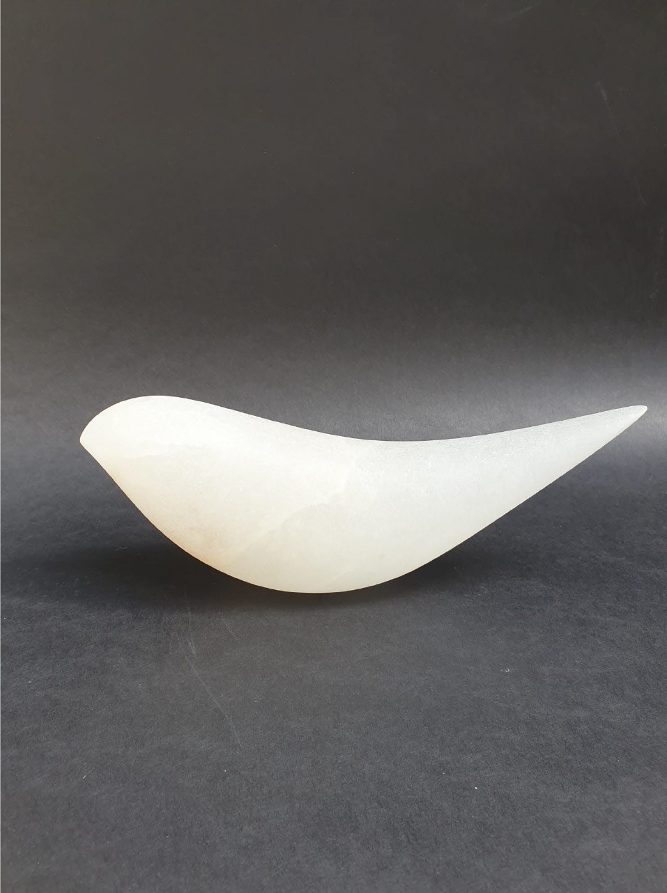 A white bowl sitting on top of a black surface.