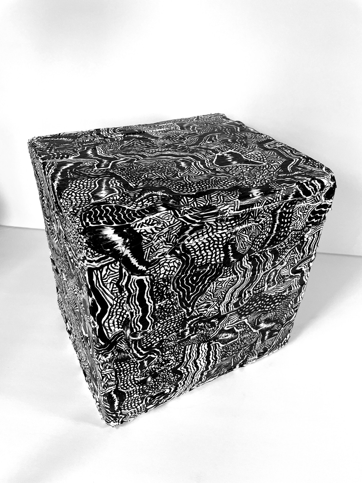 A black and white photo of a cube with a pattern on it.
