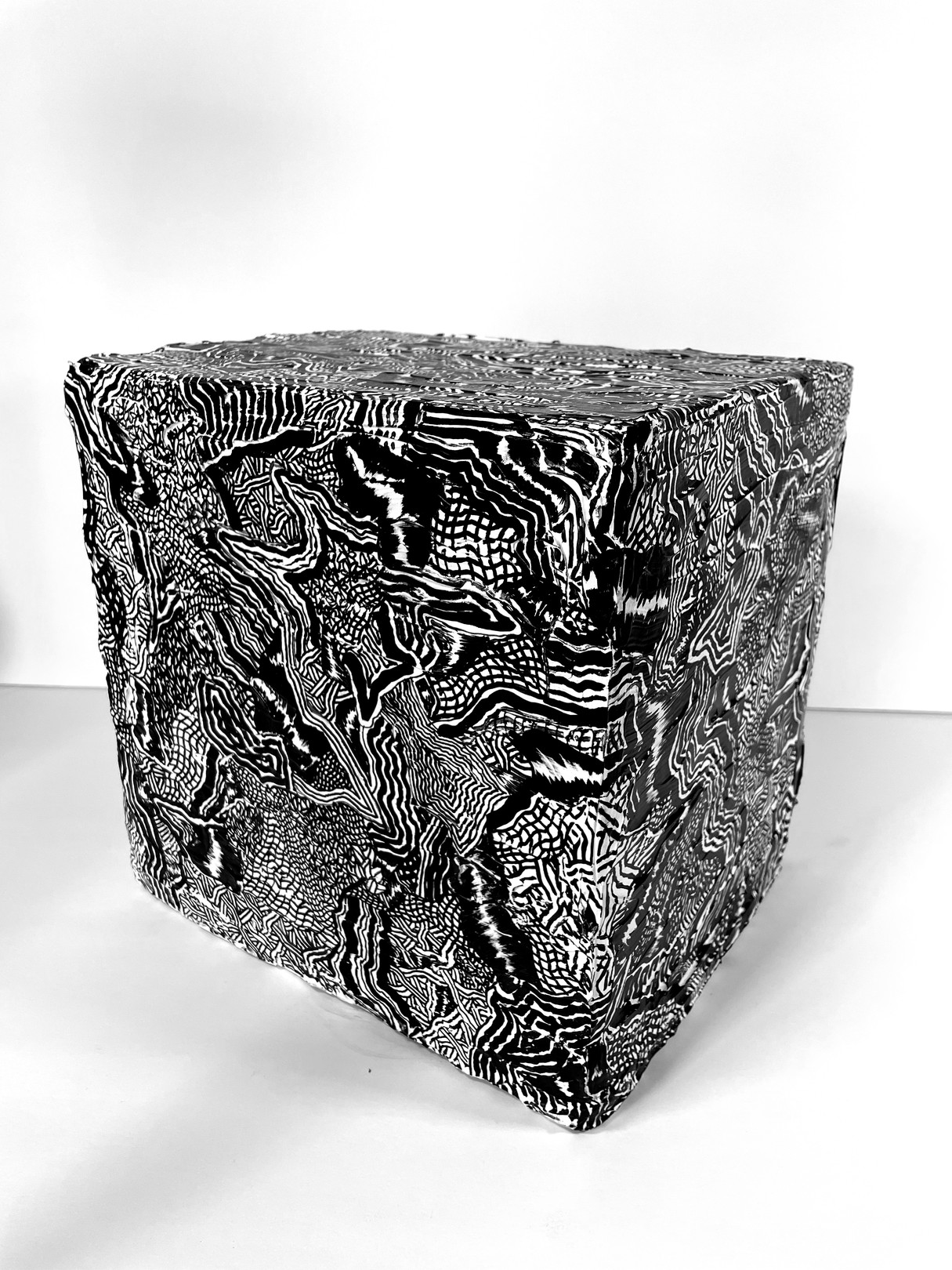 A black and white photo of a cube with a pattern on it.