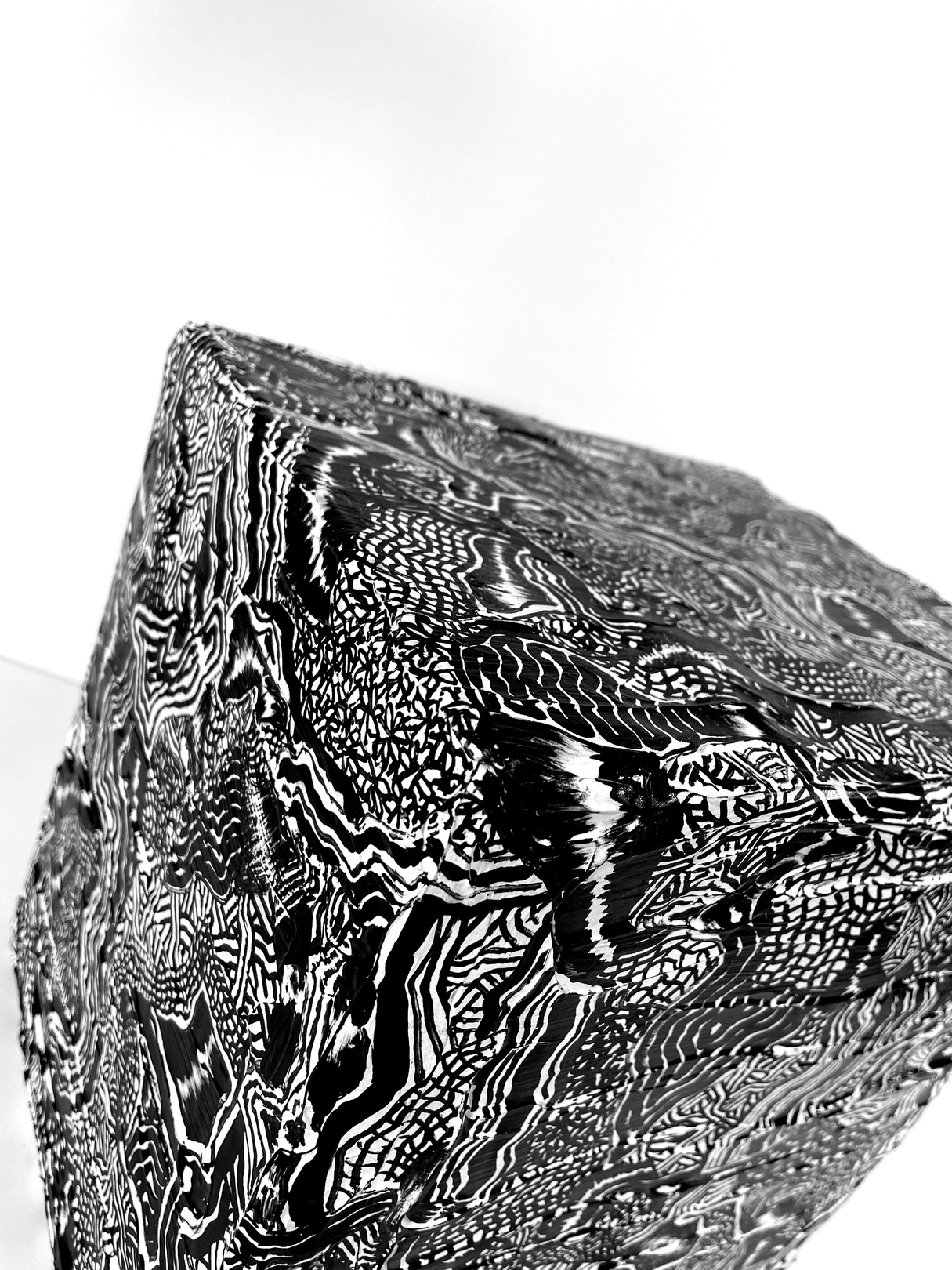 A black and white photo of a cube with a pattern on it.