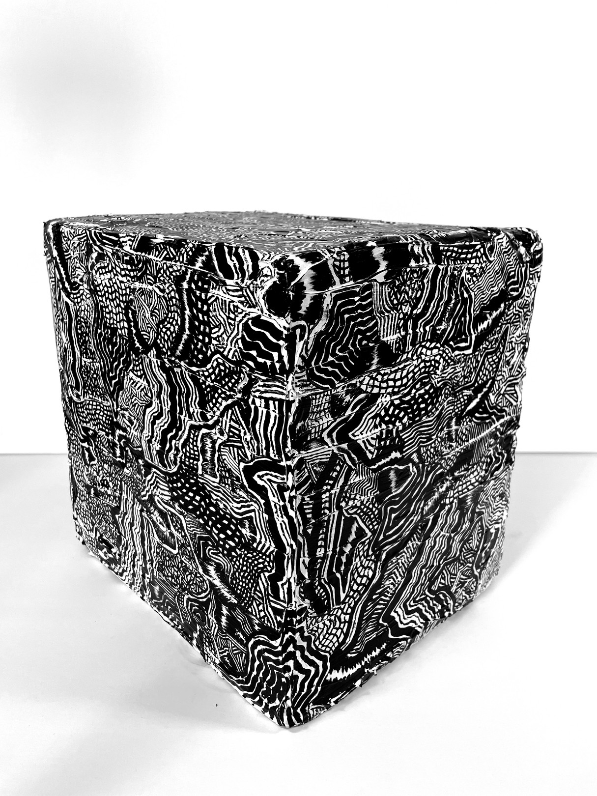 A black and white photo of a cube with a pattern on it.