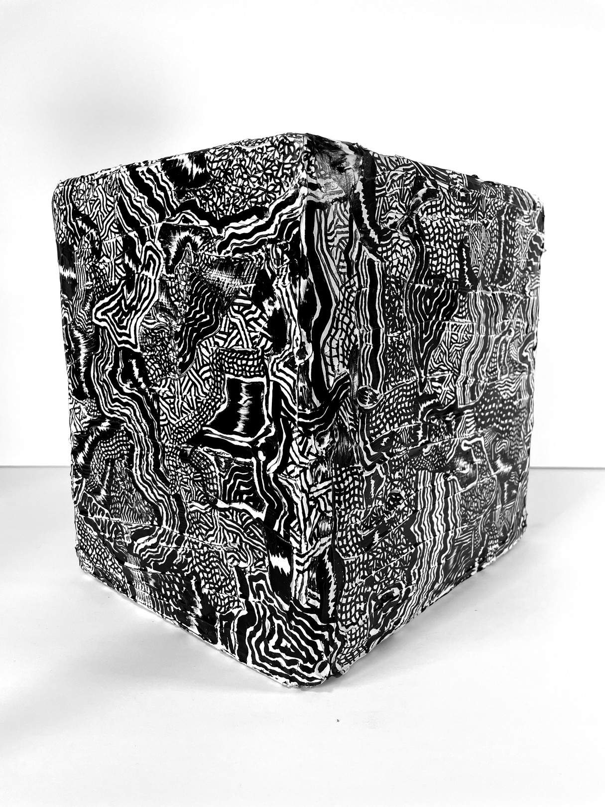 A black and white photo of a cube with a pattern on it.