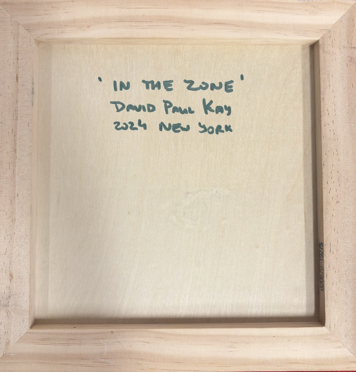 A minimalist wooden frame with handwritten text in the center.