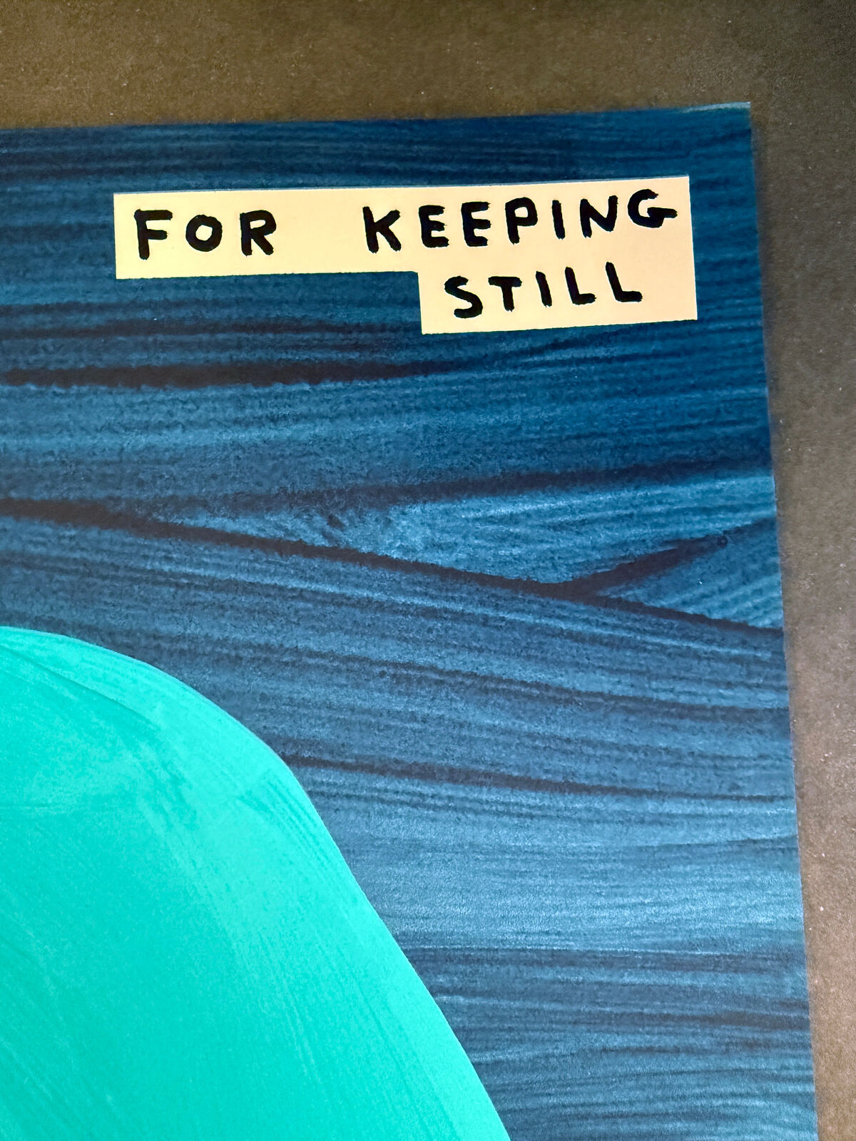 A blue painting of a nude woman sitting on the ground.