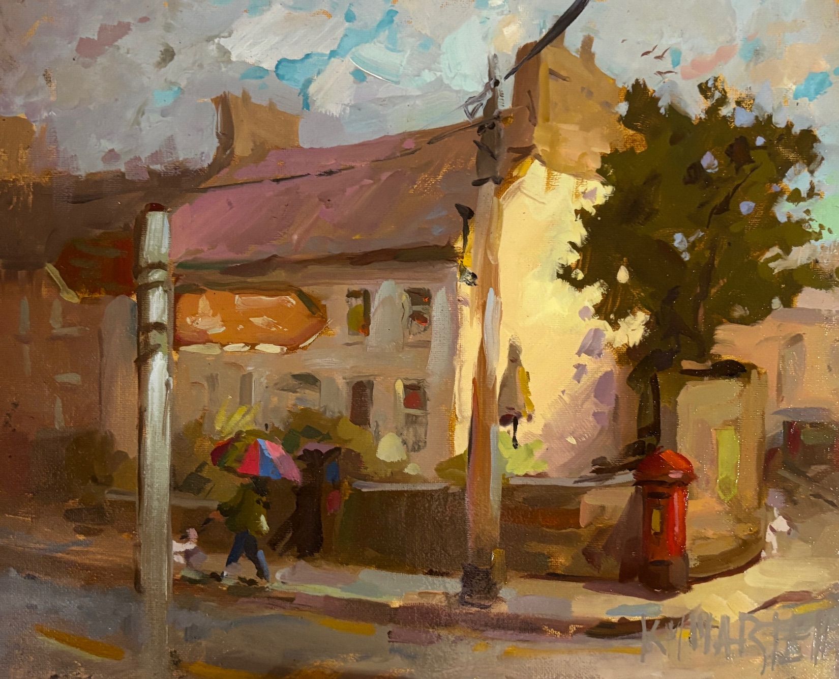 A vibrant street scene with a colorful umbrella and a red postbox.