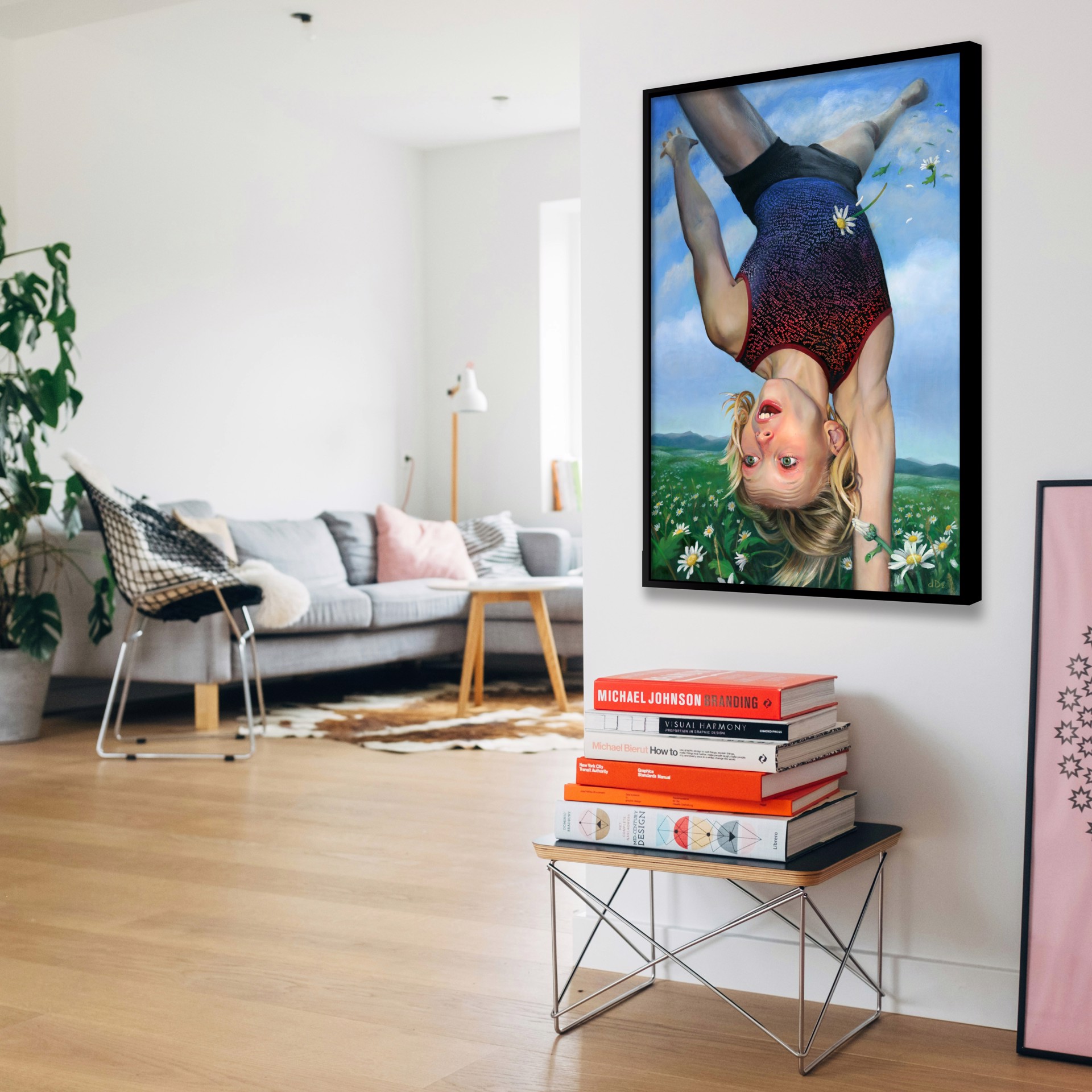 A surreal painting of a person in a leotard hanging upside down against a sky and meadow.