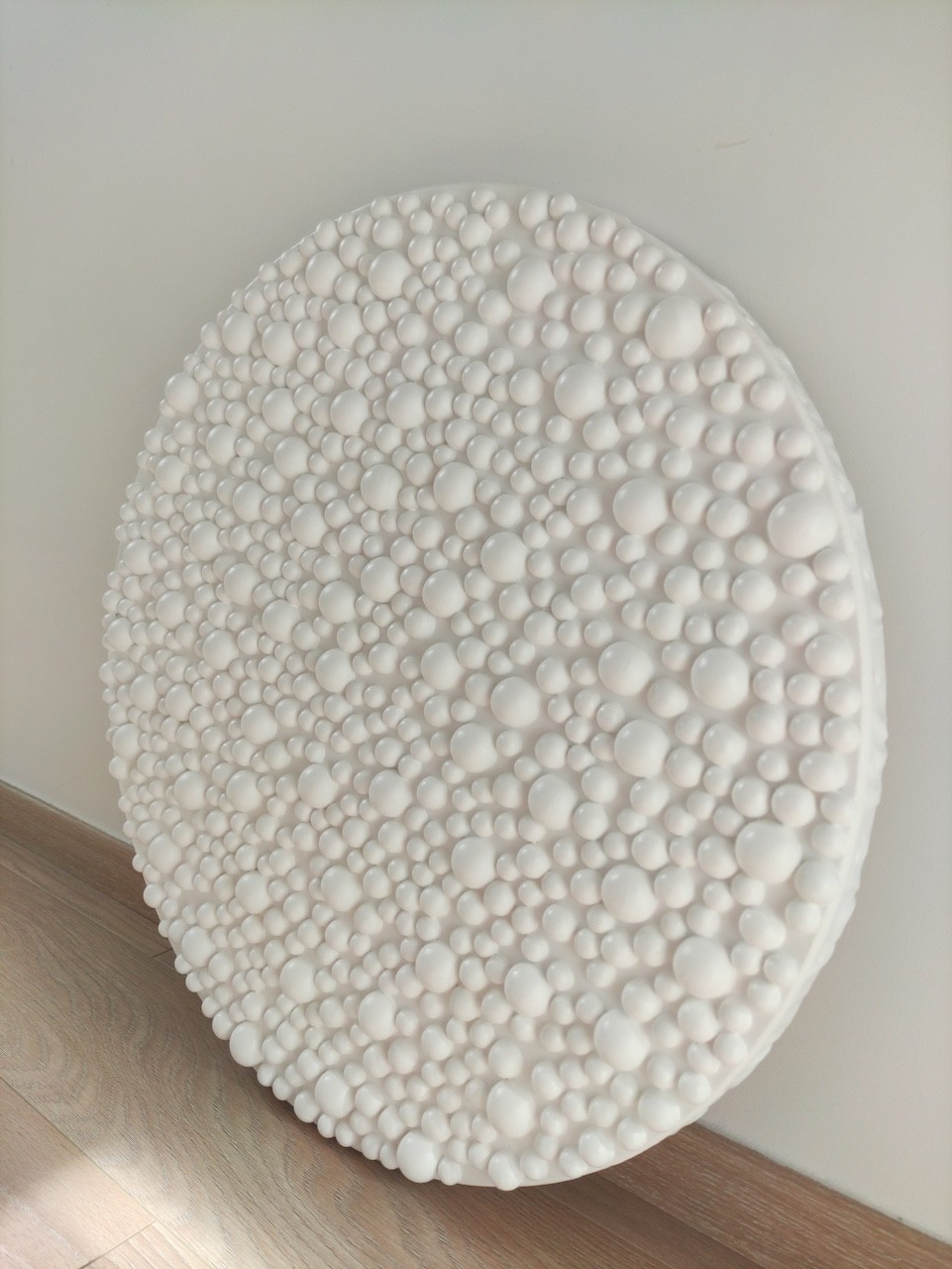 A large white plate sitting on top of a wooden easel.