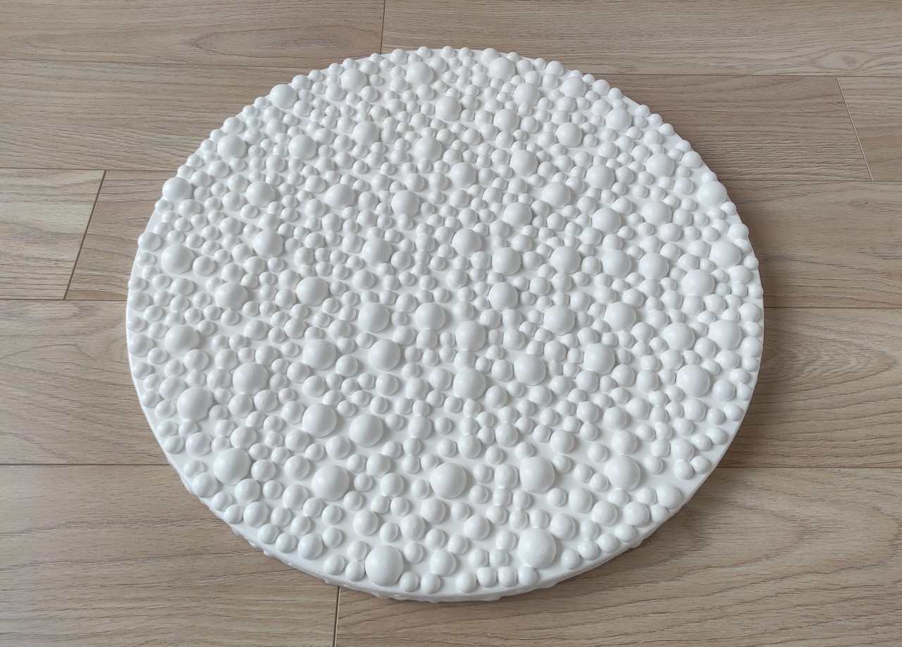 A large white plate sitting on top of a wooden easel.
