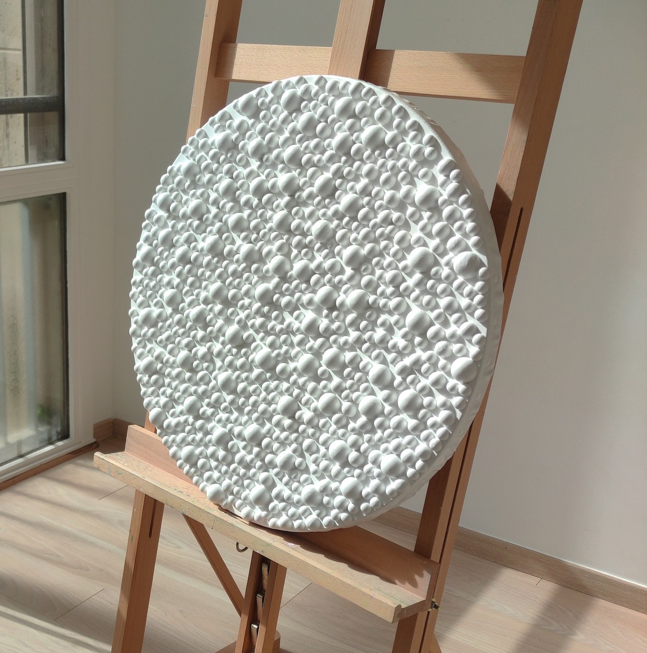 A large white plate sitting on top of a wooden easel.
