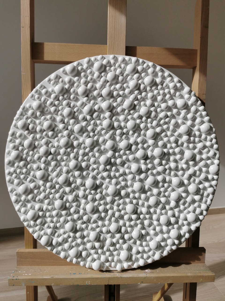 A large white plate sitting on top of a wooden easel.