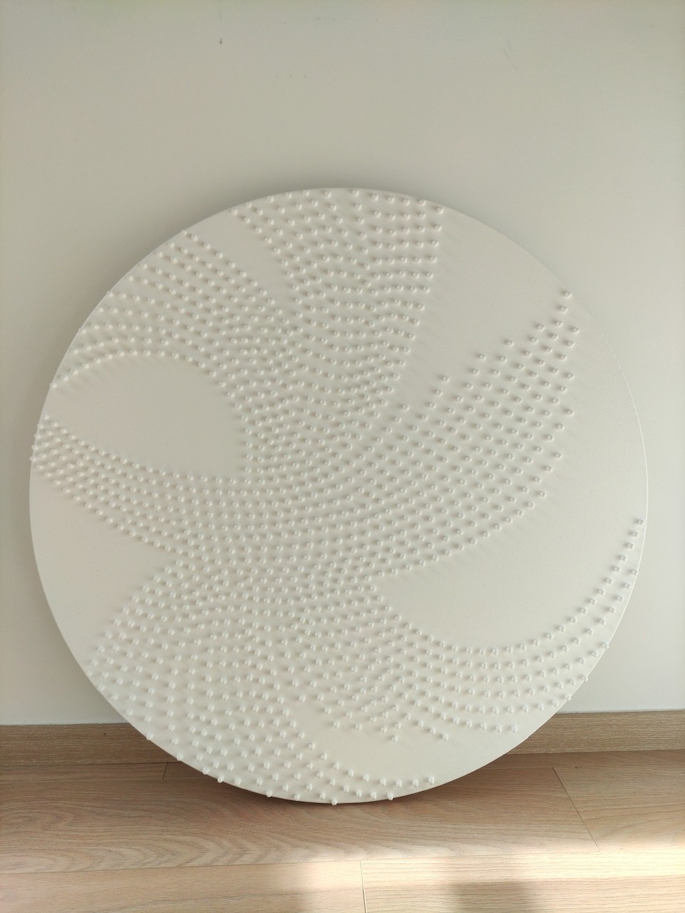 A large white plate sitting on top of a wooden stand.