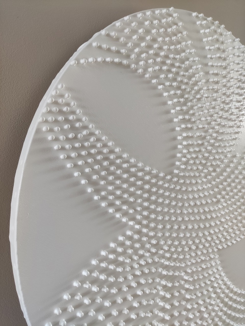 A large white plate sitting on top of a wooden stand.