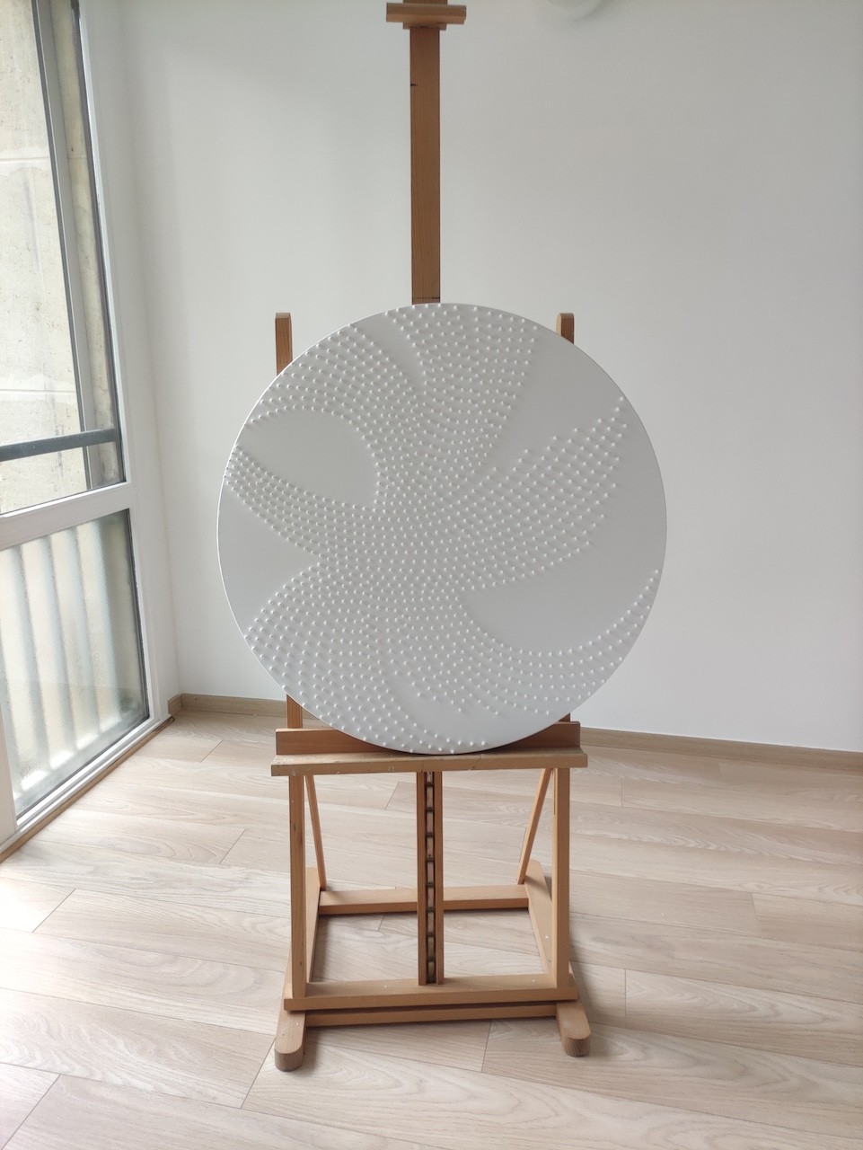 A large white plate sitting on top of a wooden stand.