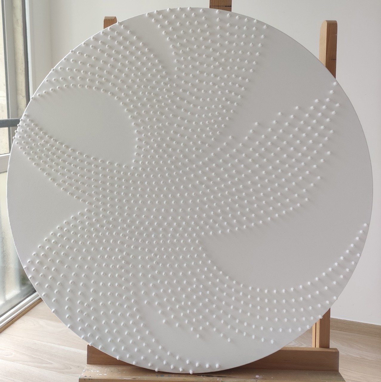 A large white plate sitting on top of a wooden stand.