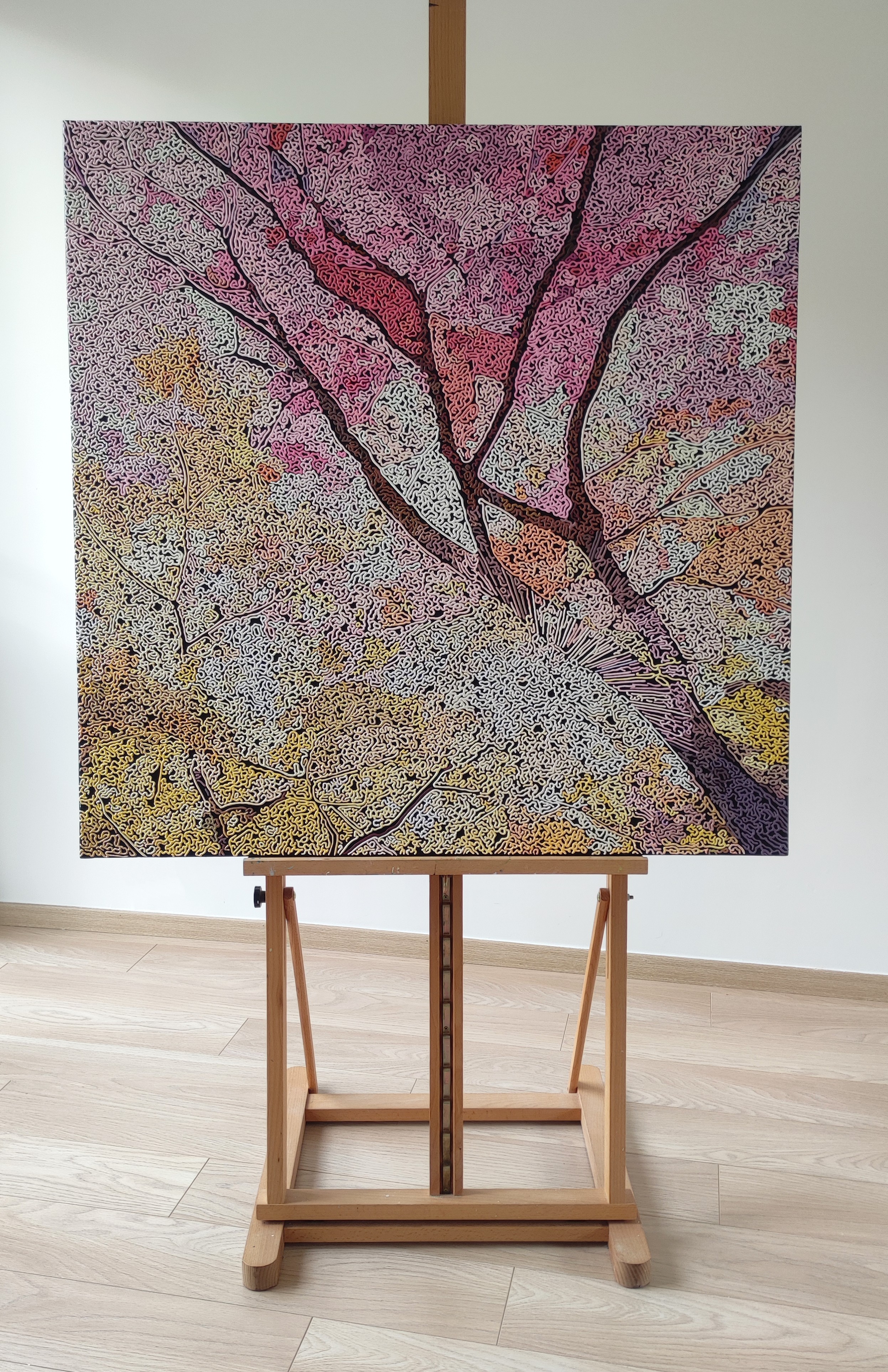 A painting of a tree on a wall in a room.