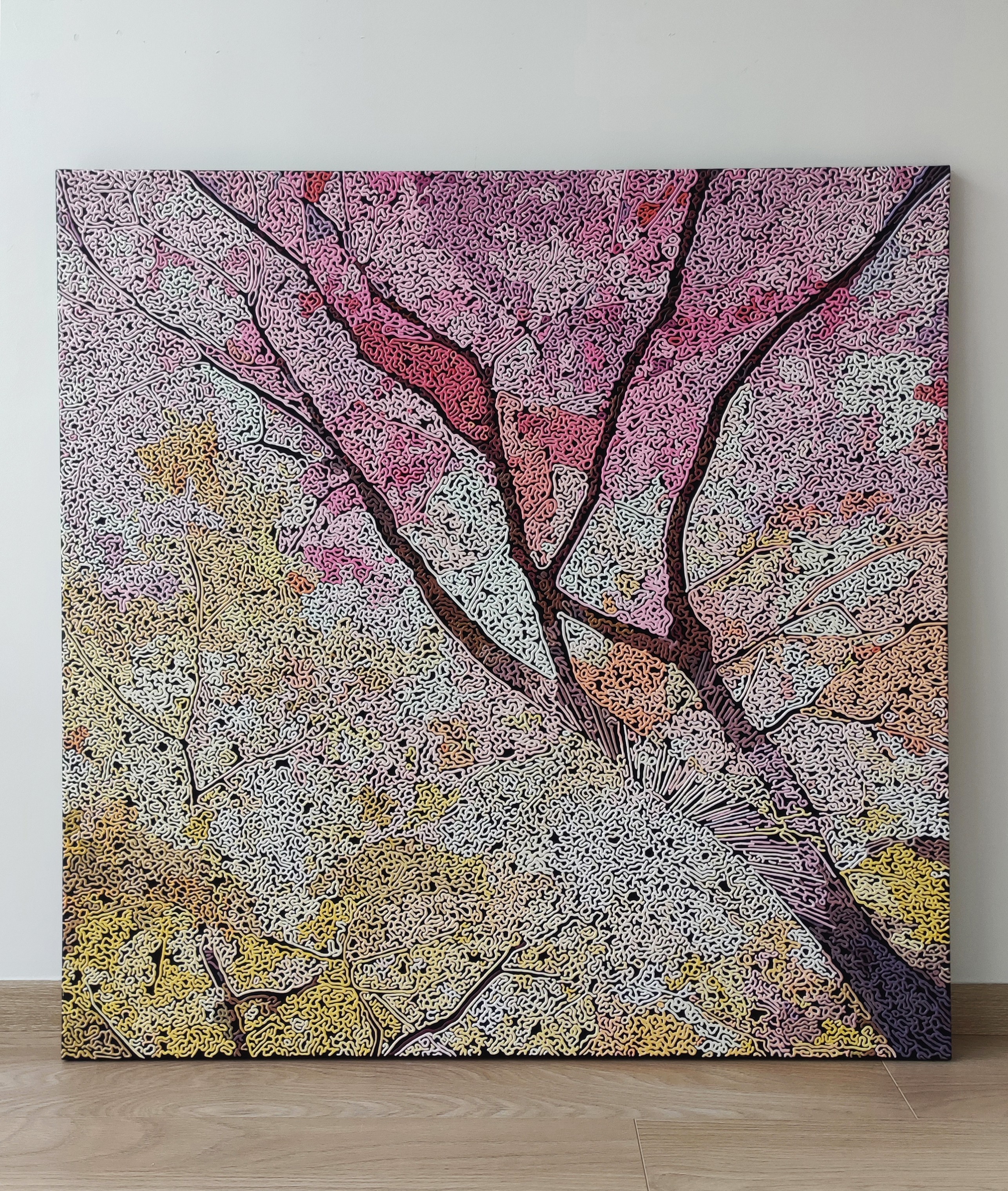 A painting of a tree on a wall in a room.