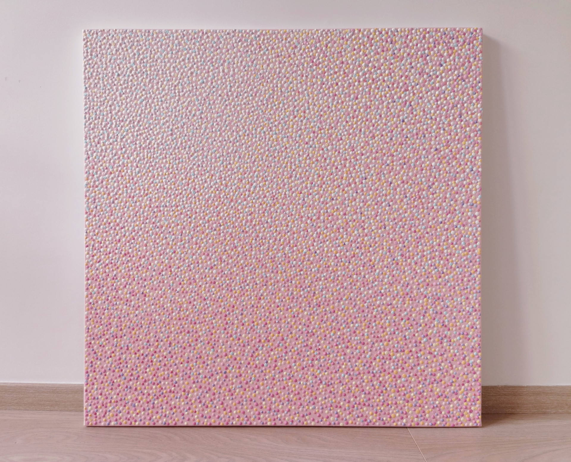 A close up of a pink fabric with small dots on it.