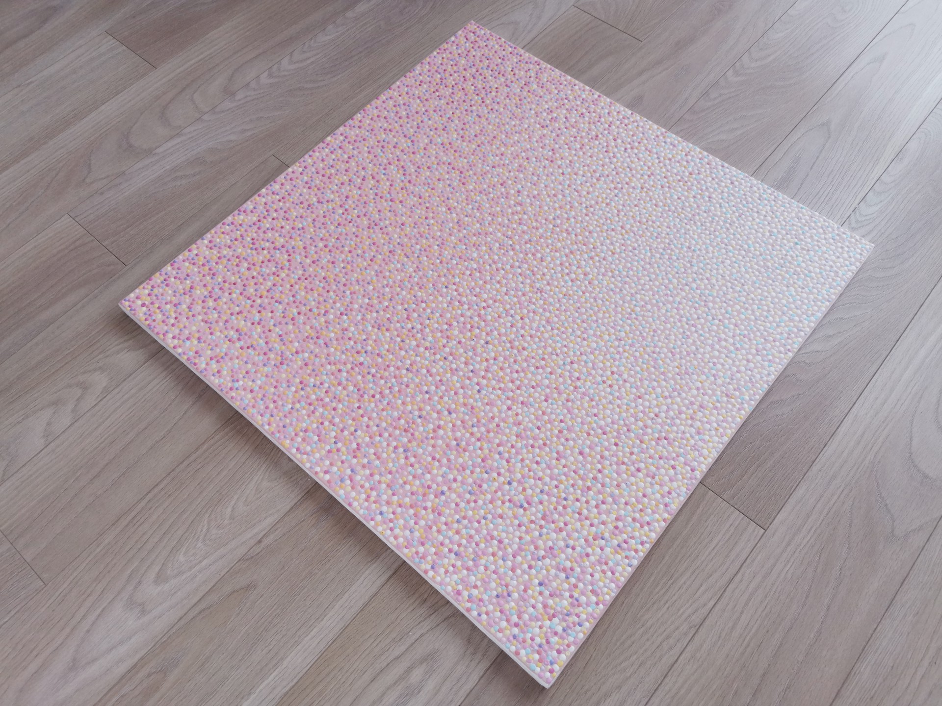A close up of a pink fabric with small dots on it.