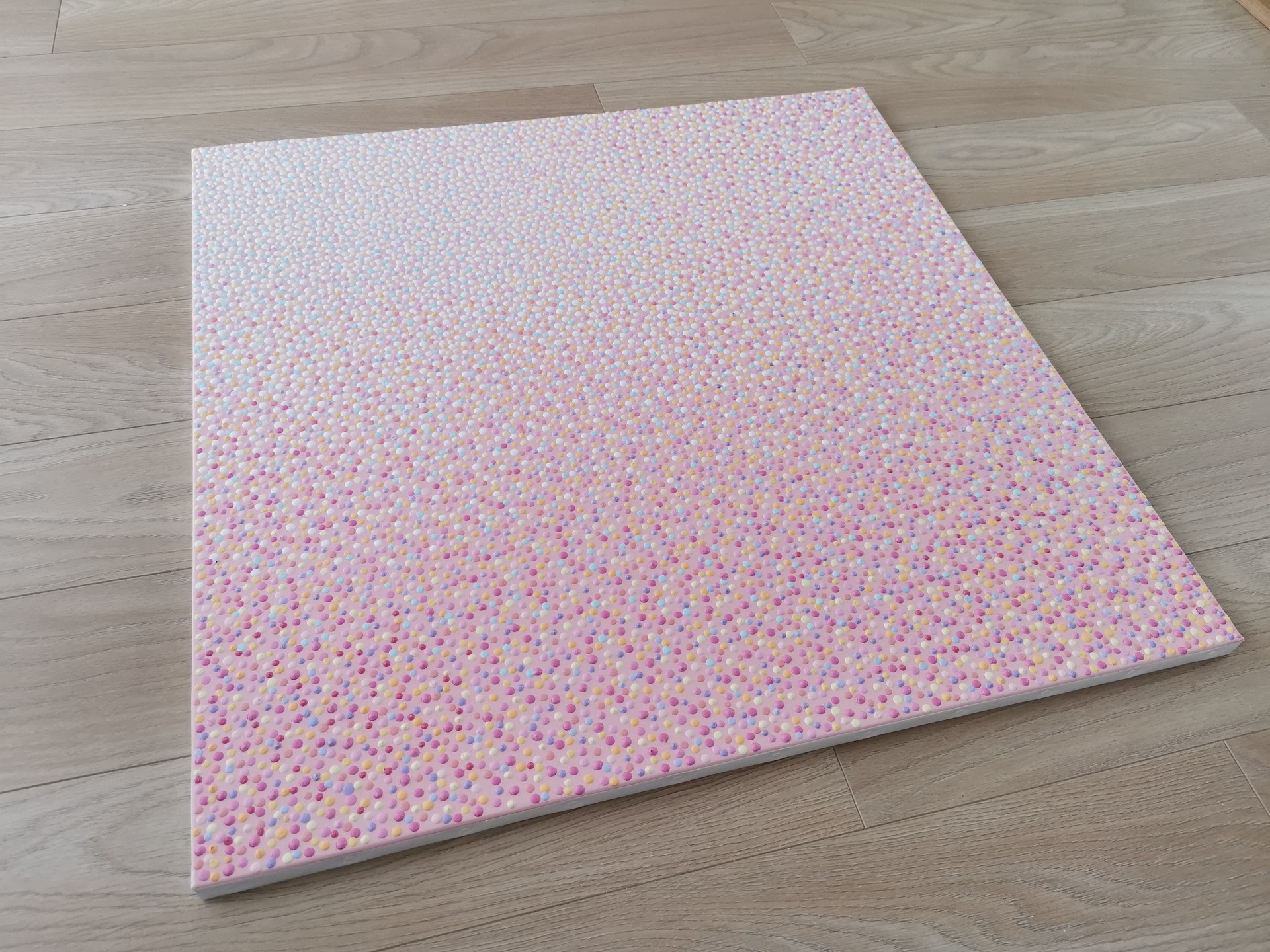 A close up of a pink fabric with small dots on it.