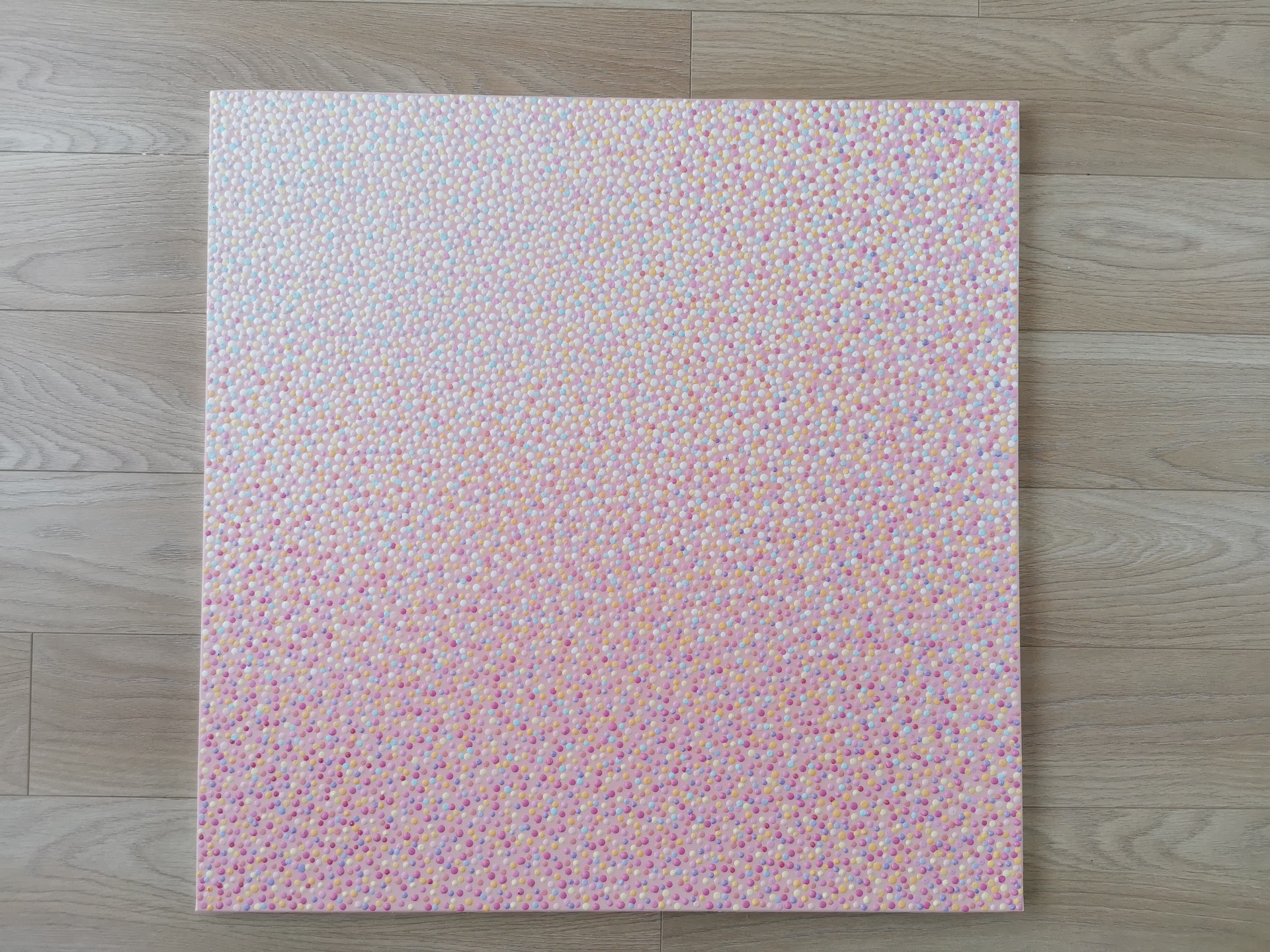 A close up of a pink fabric with small dots on it.