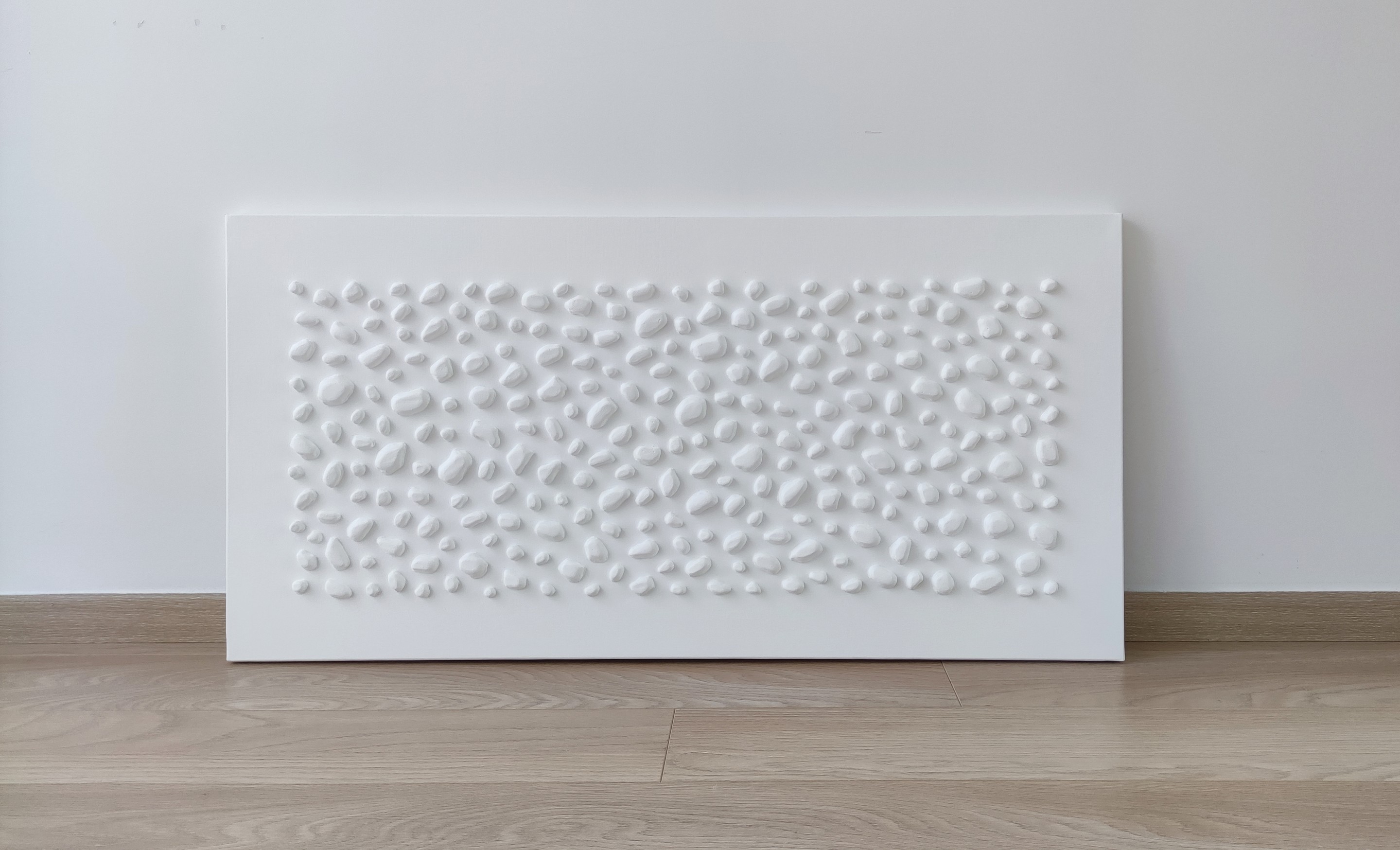 A white wall with a large white sculpture on it.