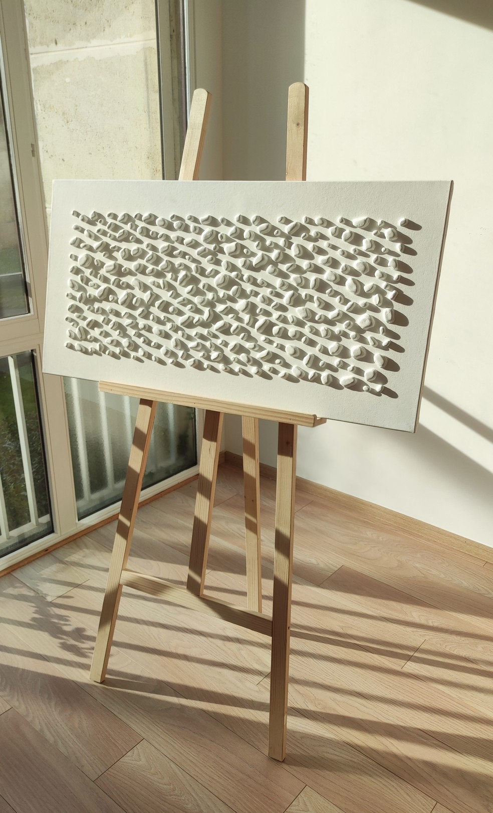 A white wall with a large white sculpture on it.