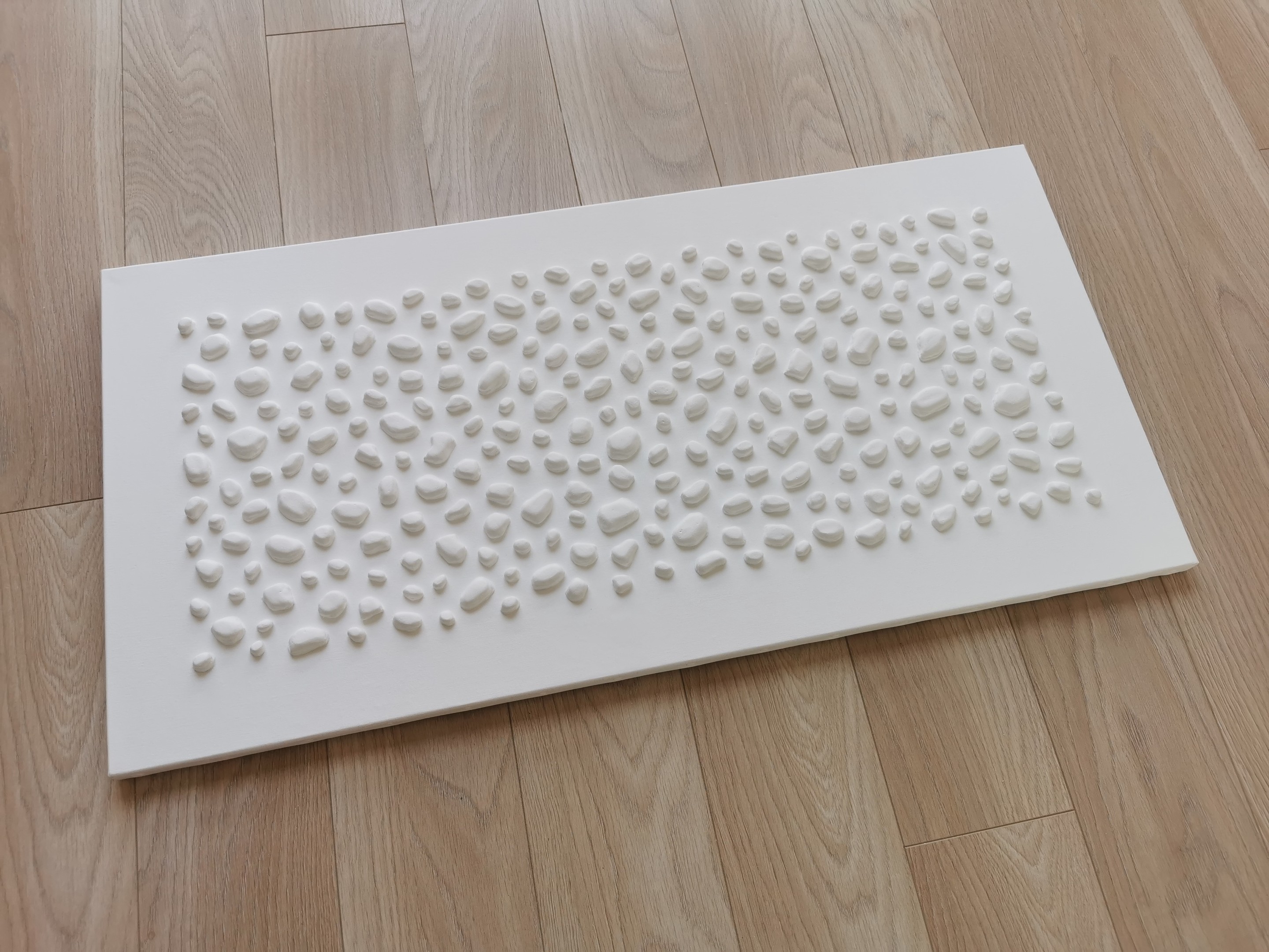 A white wall with a large white sculpture on it.