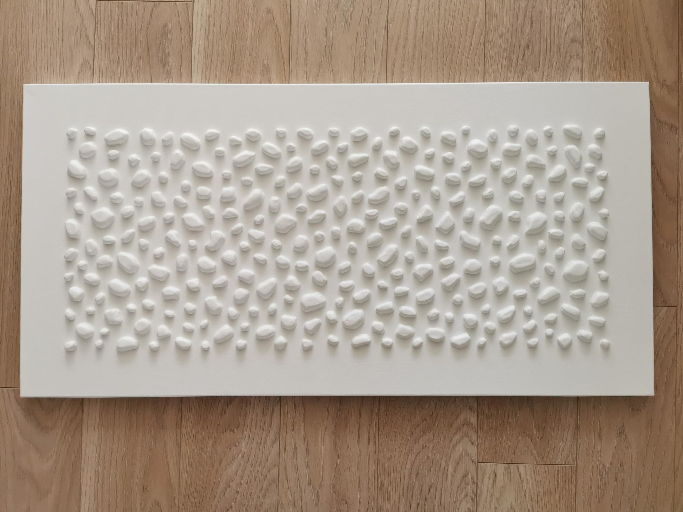 A white wall with a large white sculpture on it.