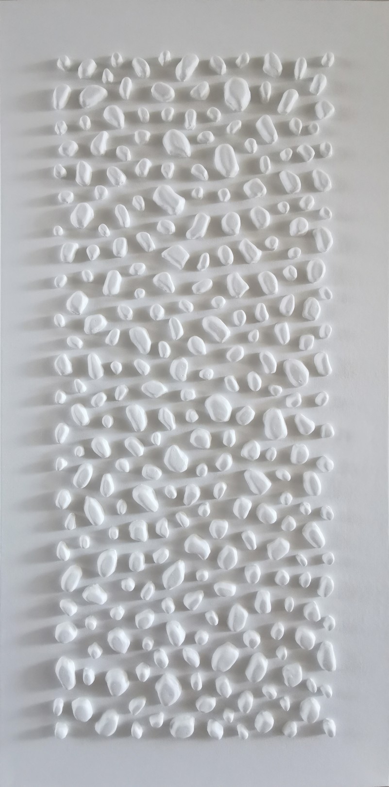 A white wall with a large white sculpture on it.