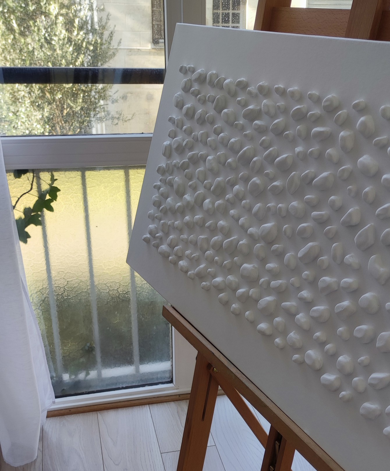 A white wall with a large white sculpture on it.