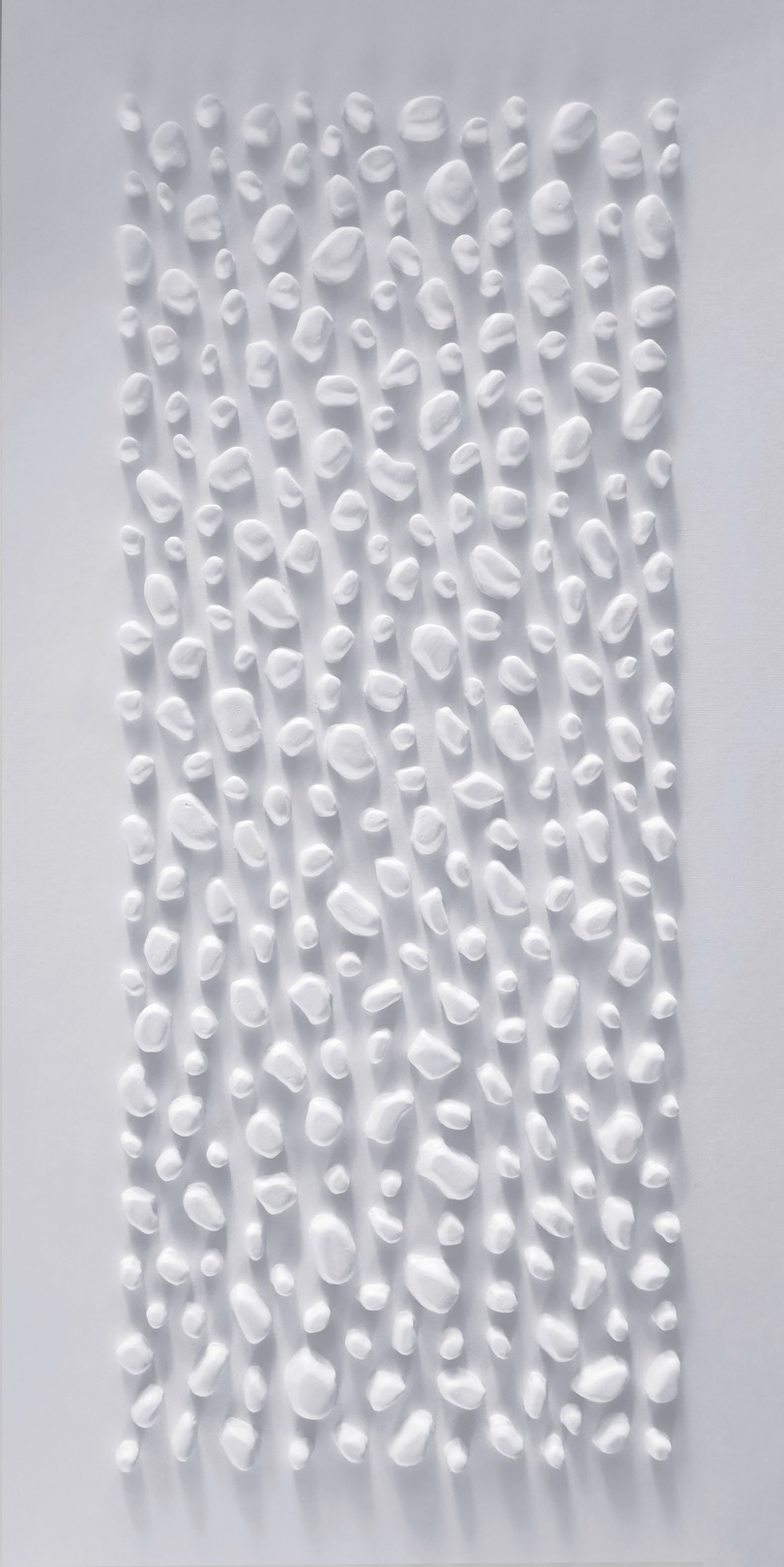 A white wall with a large white sculpture on it.