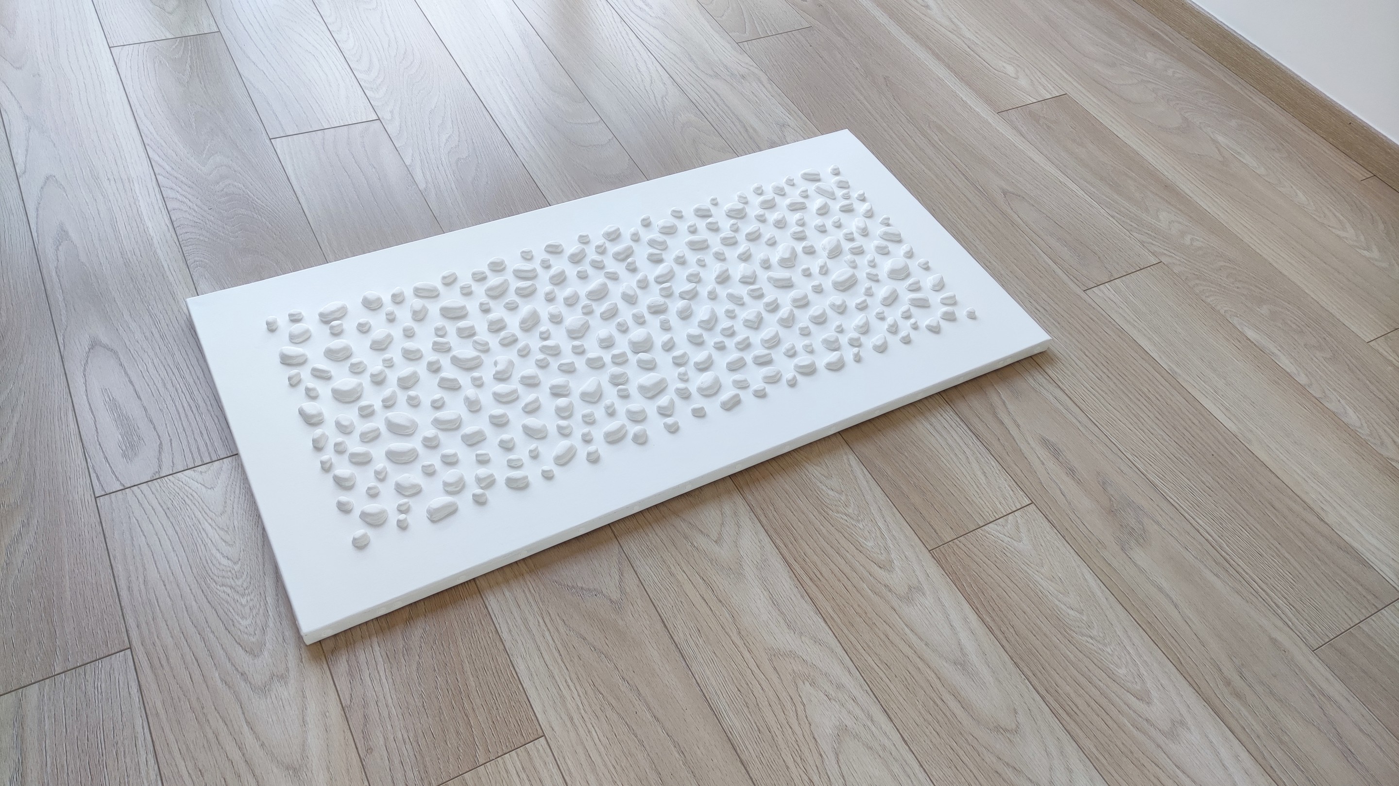 A white wall with a large white sculpture on it.